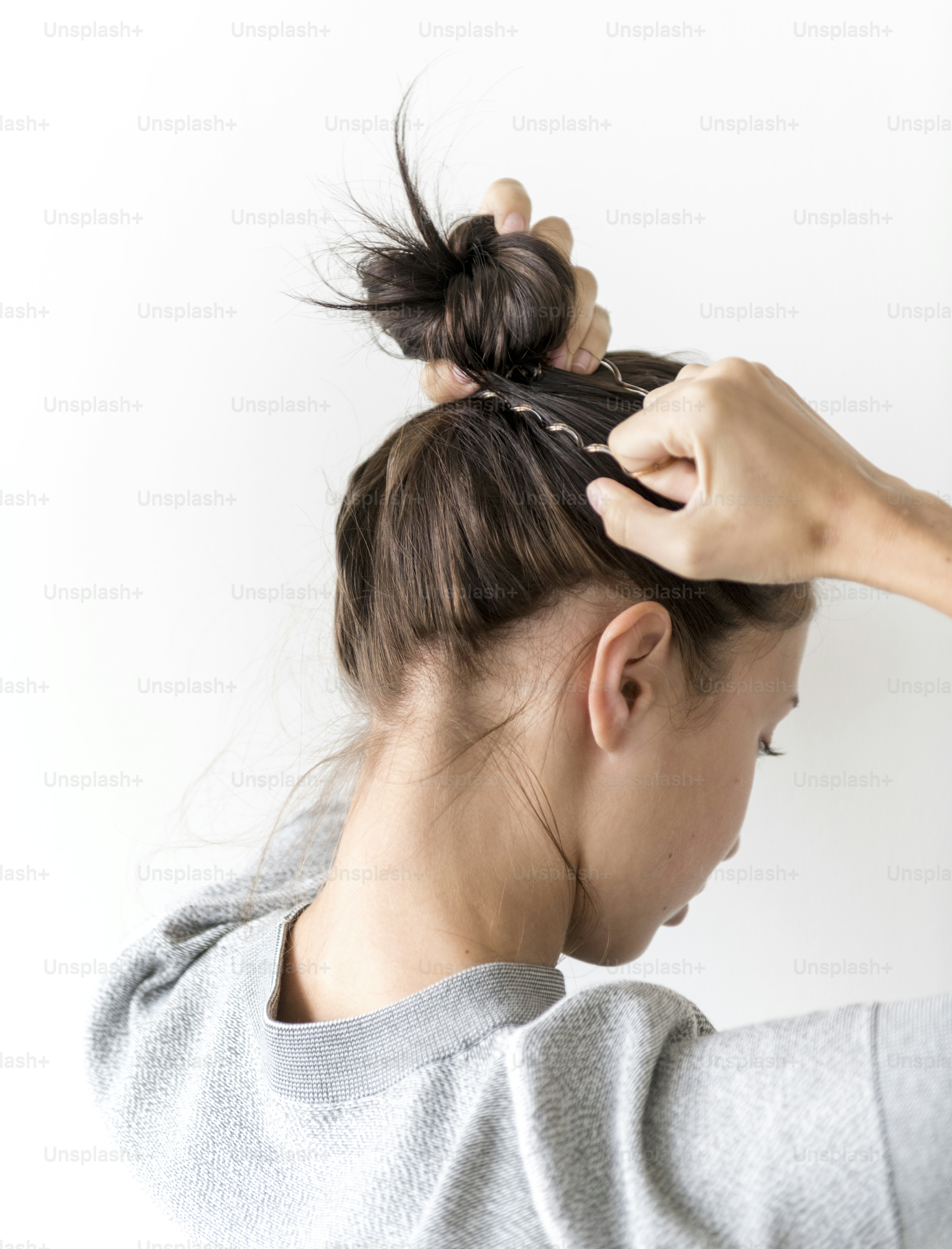 Femme faisant des cheveux chignon