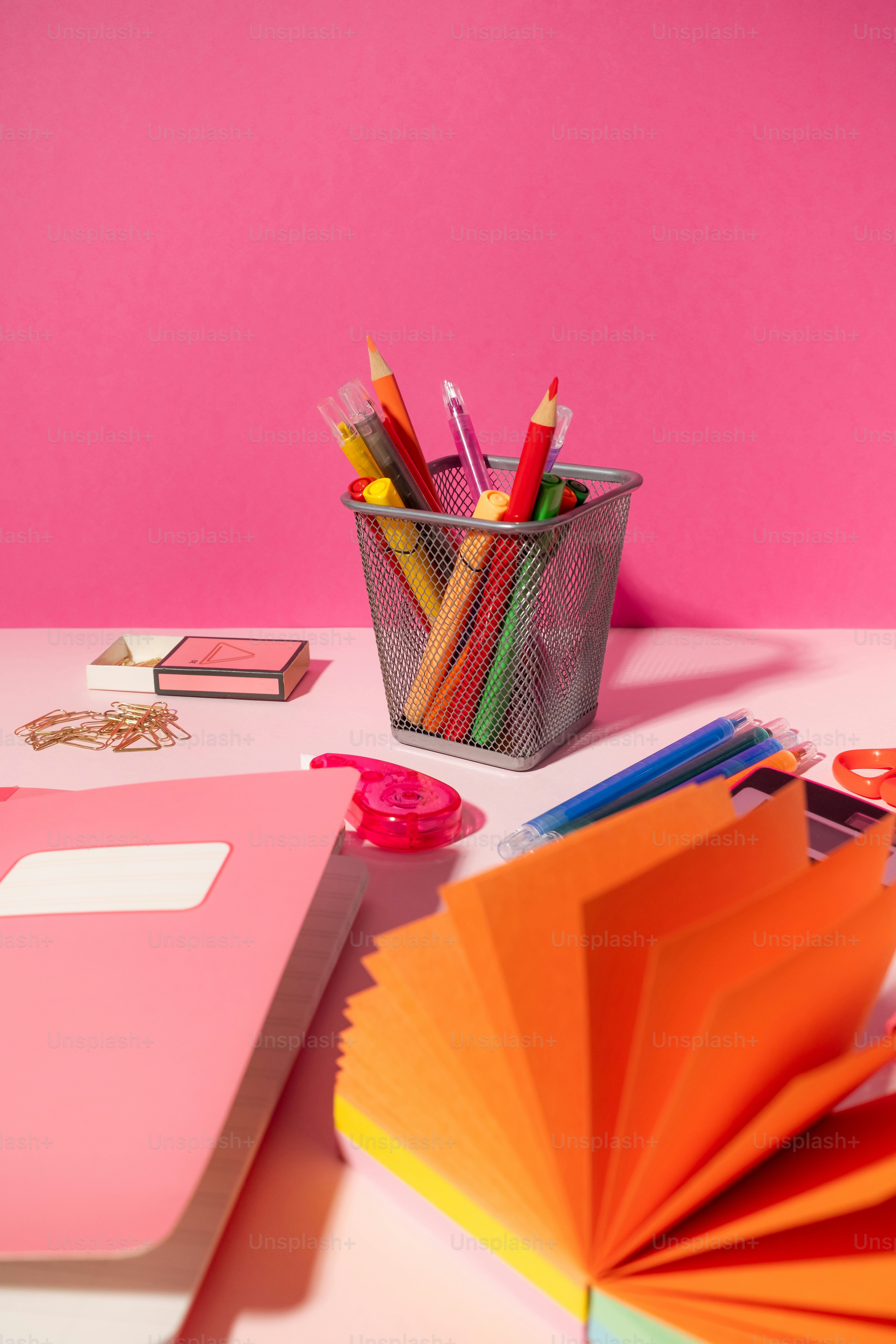 Uma mesa com uma xícara de lápis e um caderno