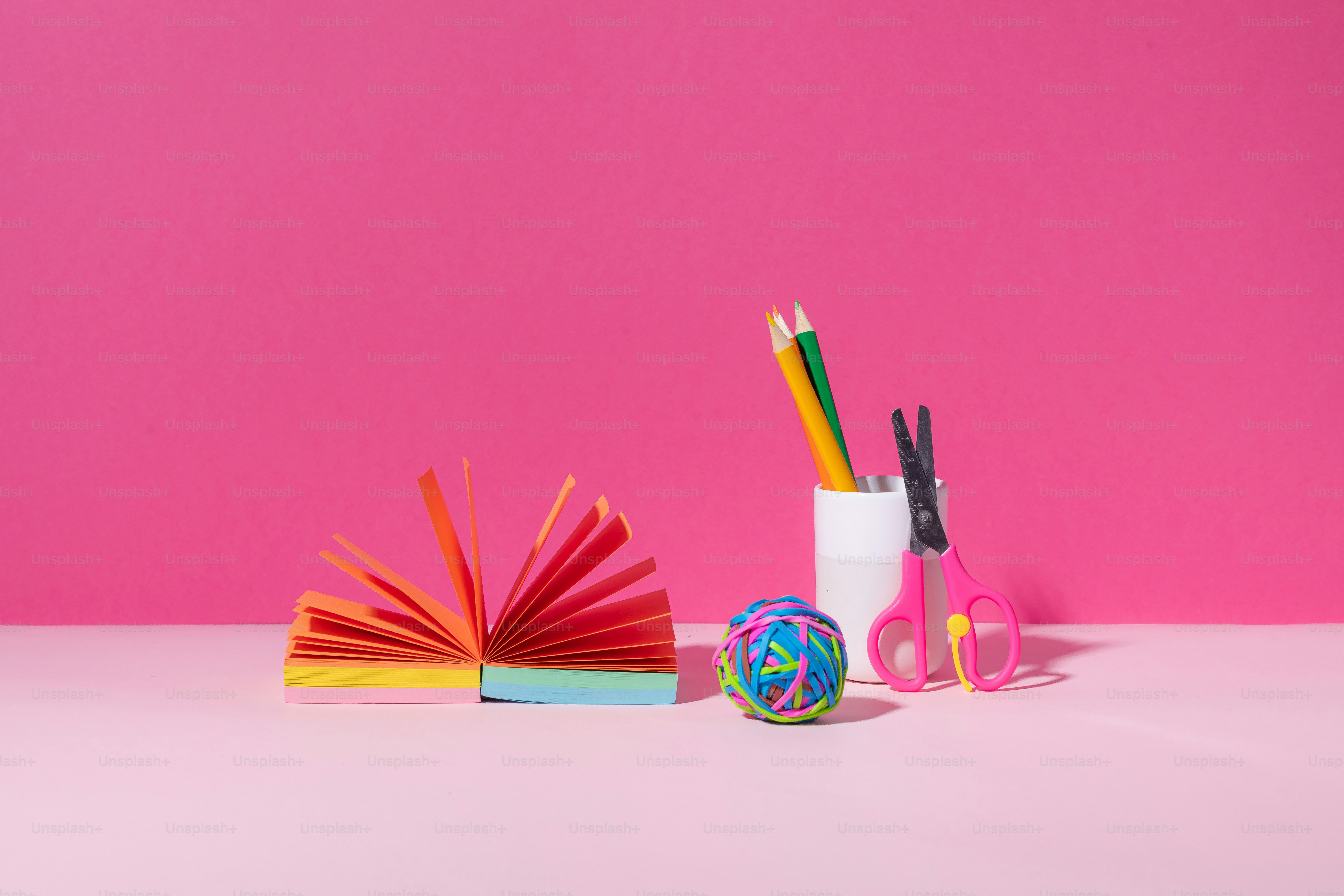 A desk with a book, pencils, and a ball of yarn
