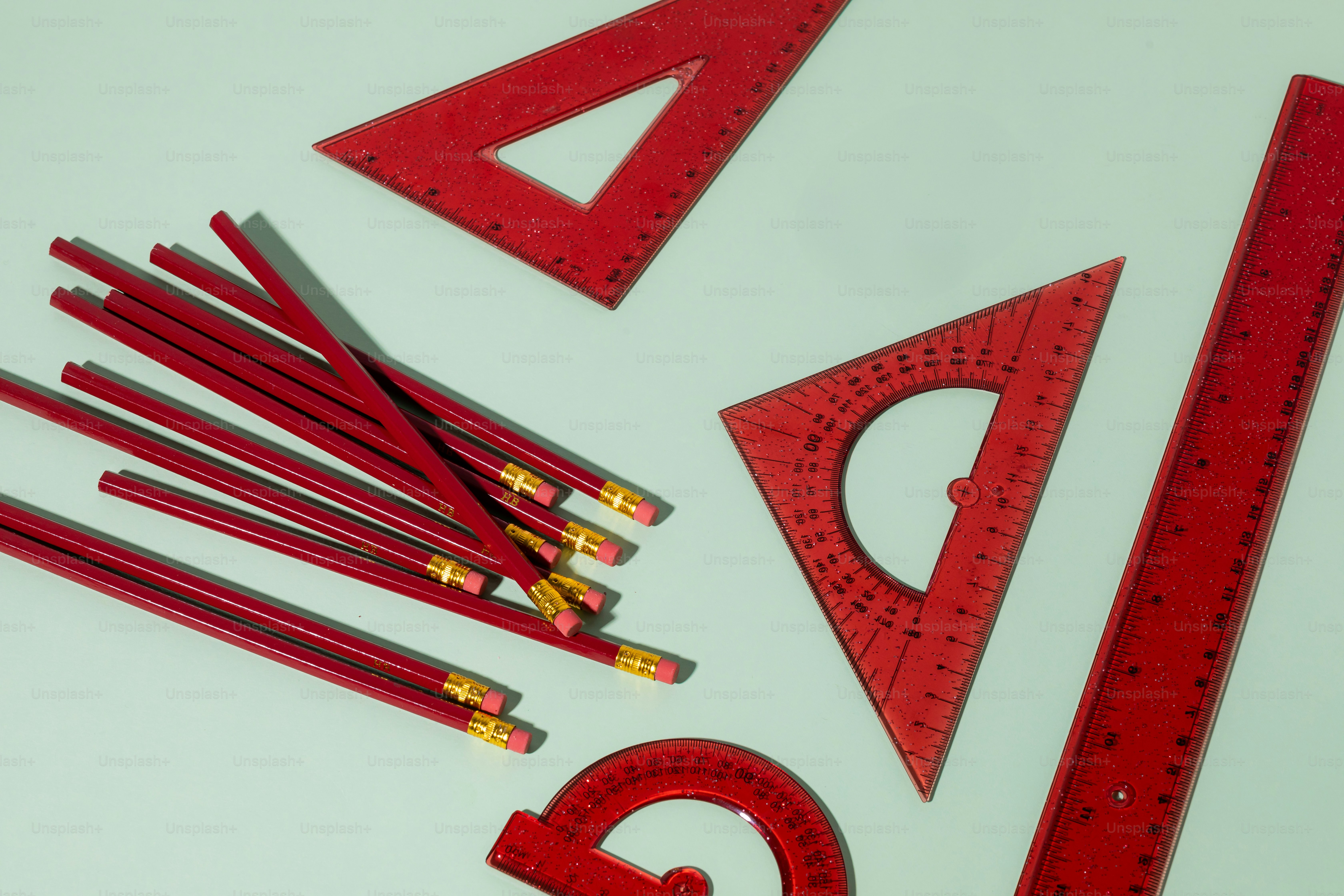 A group of red pencils sitting on top of a white table