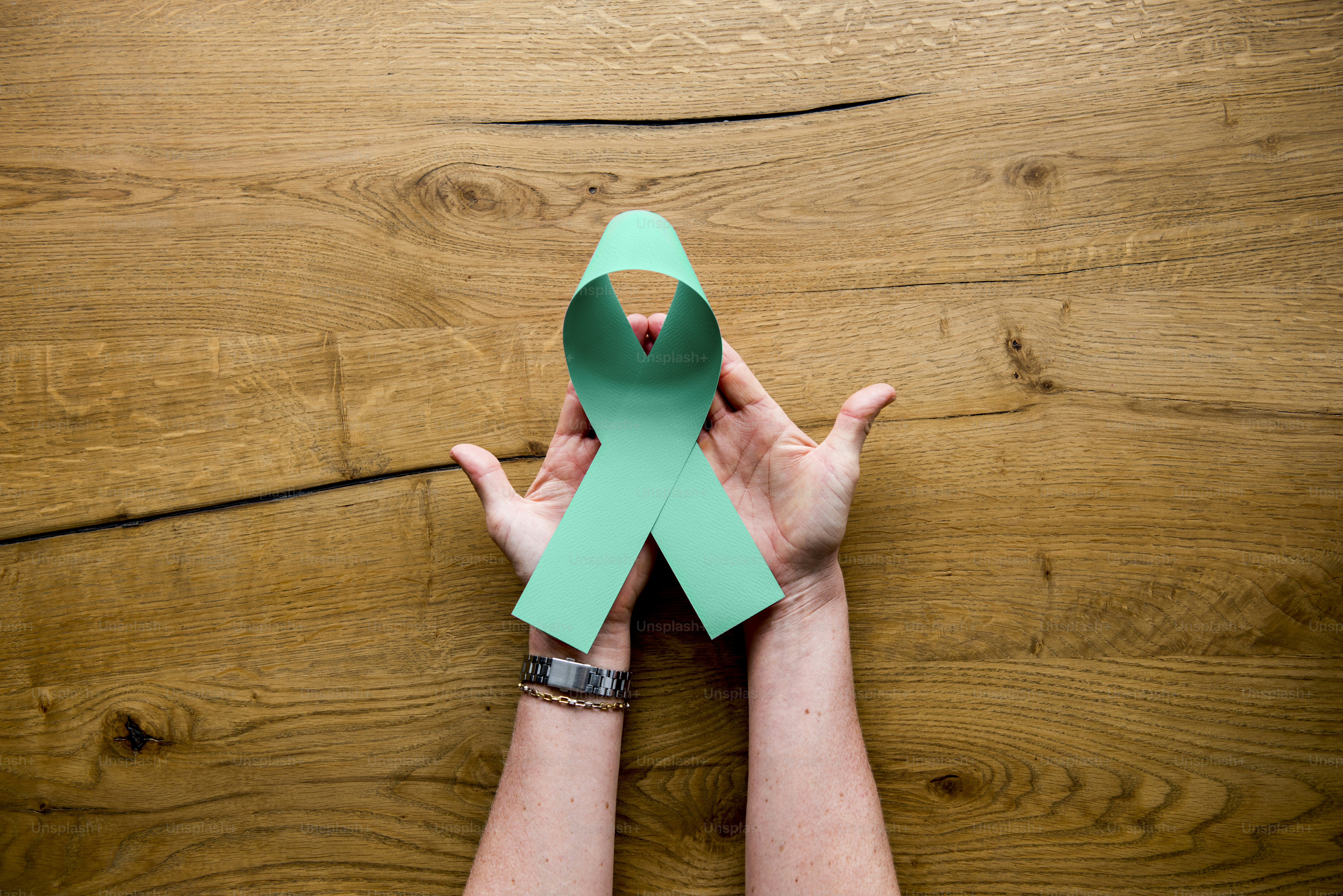 Le mani si tengono mostrando la donazione di organi con nastro verde