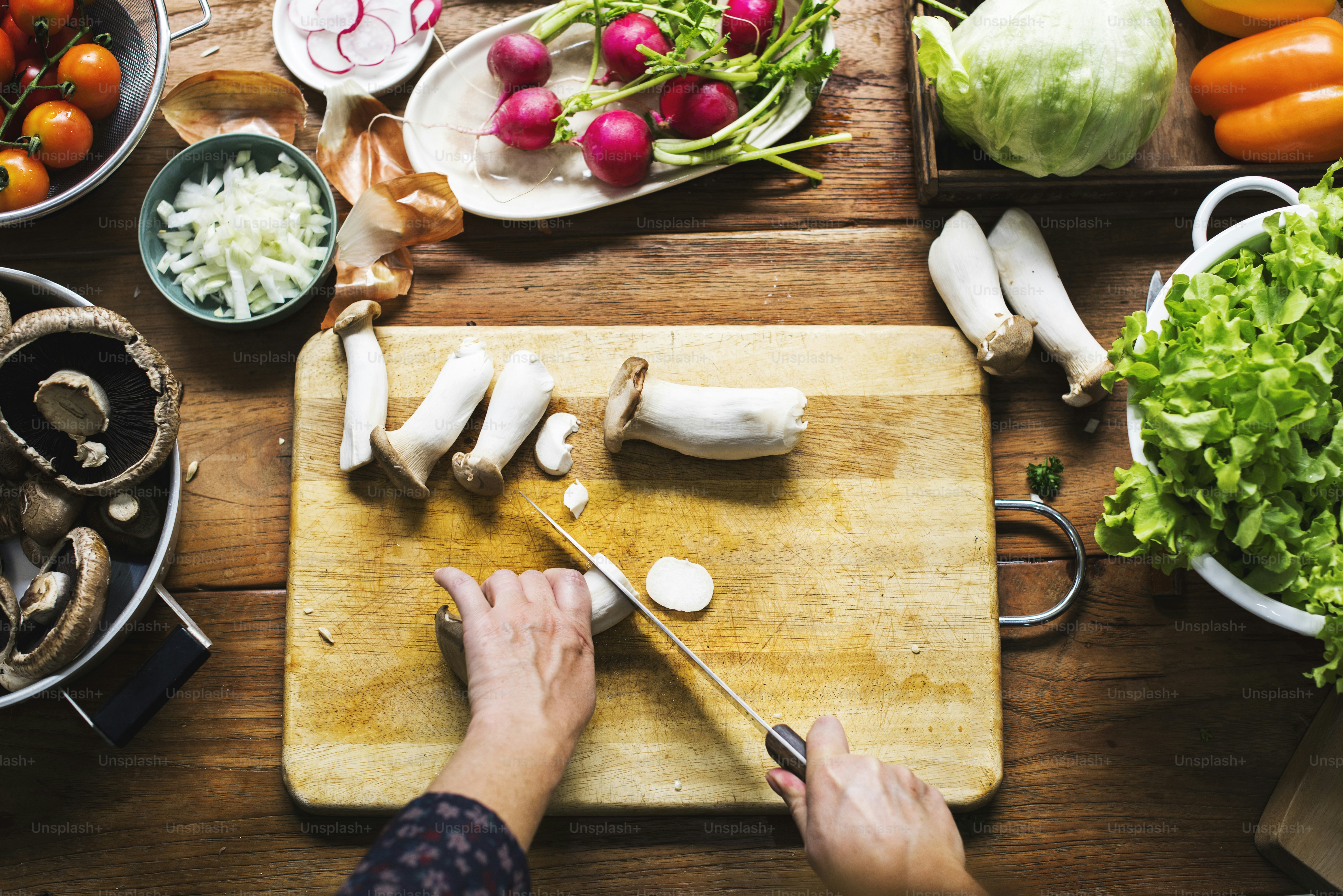 Vista aérea de la mano con el cuchillo cortando el hongo