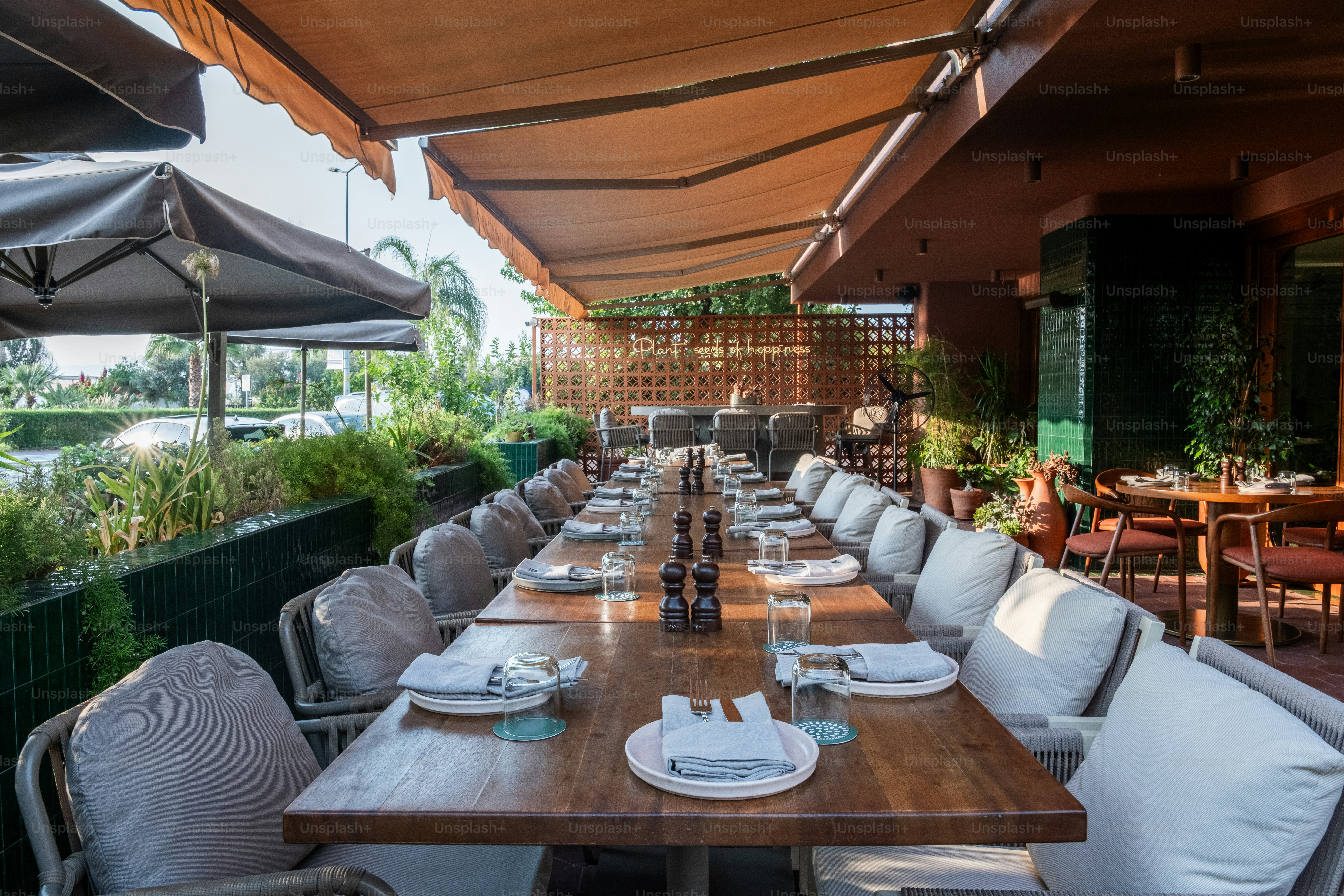 A long wooden table with white plates on it