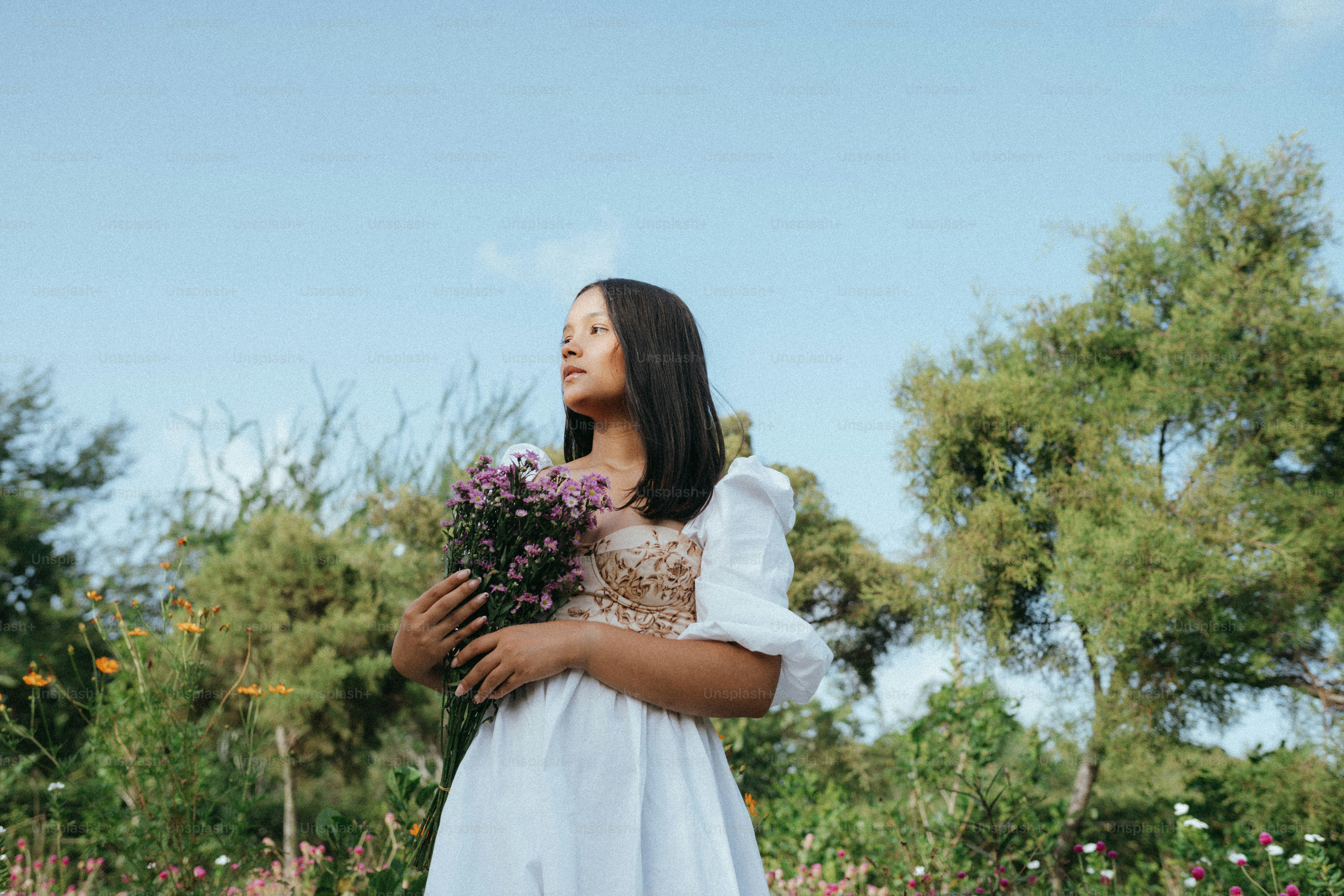 A woman in a yellow dress holding a bunch of flowers photo – Bouquet ...