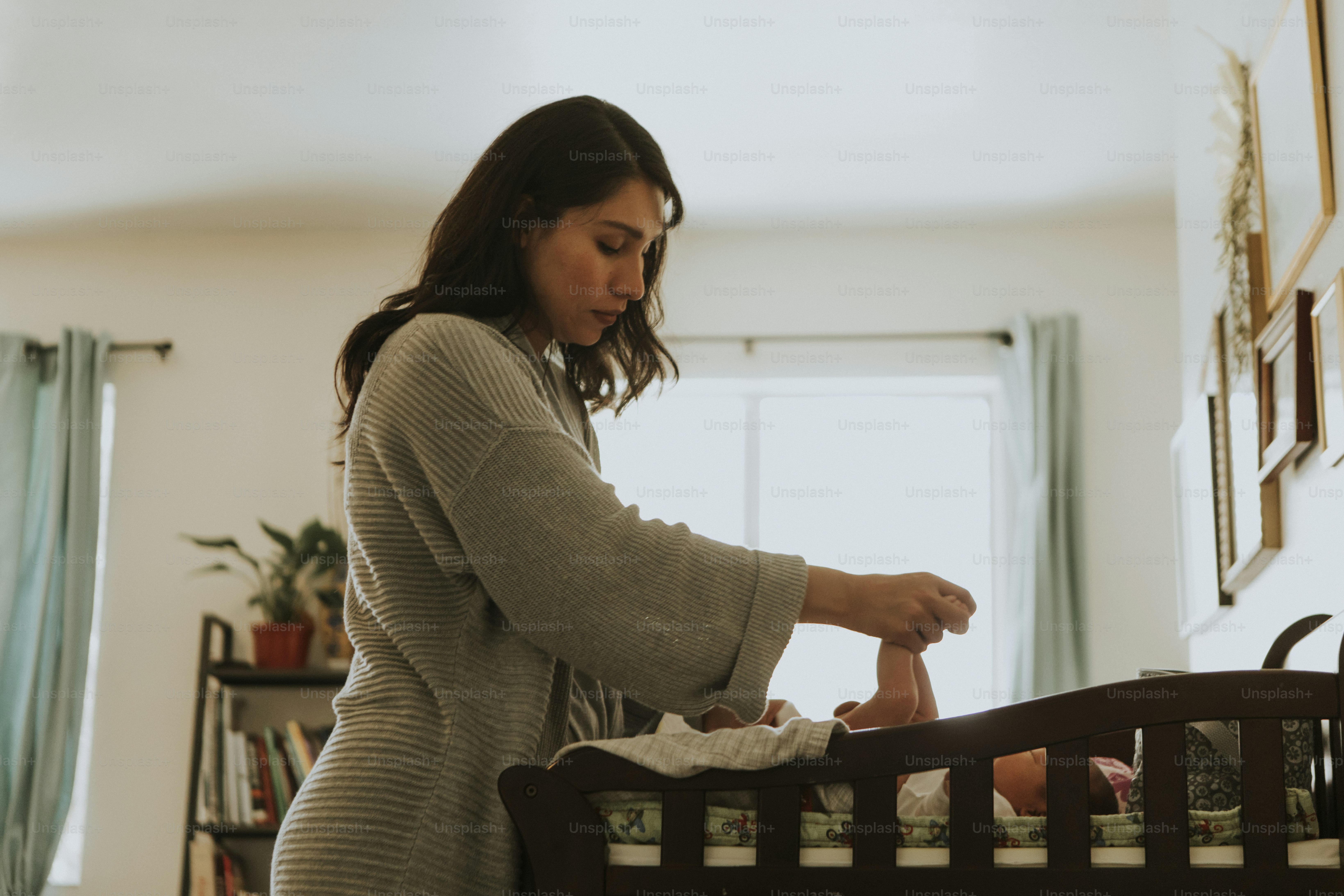 Mother caring for her newborn baby during an everyday nursery routine