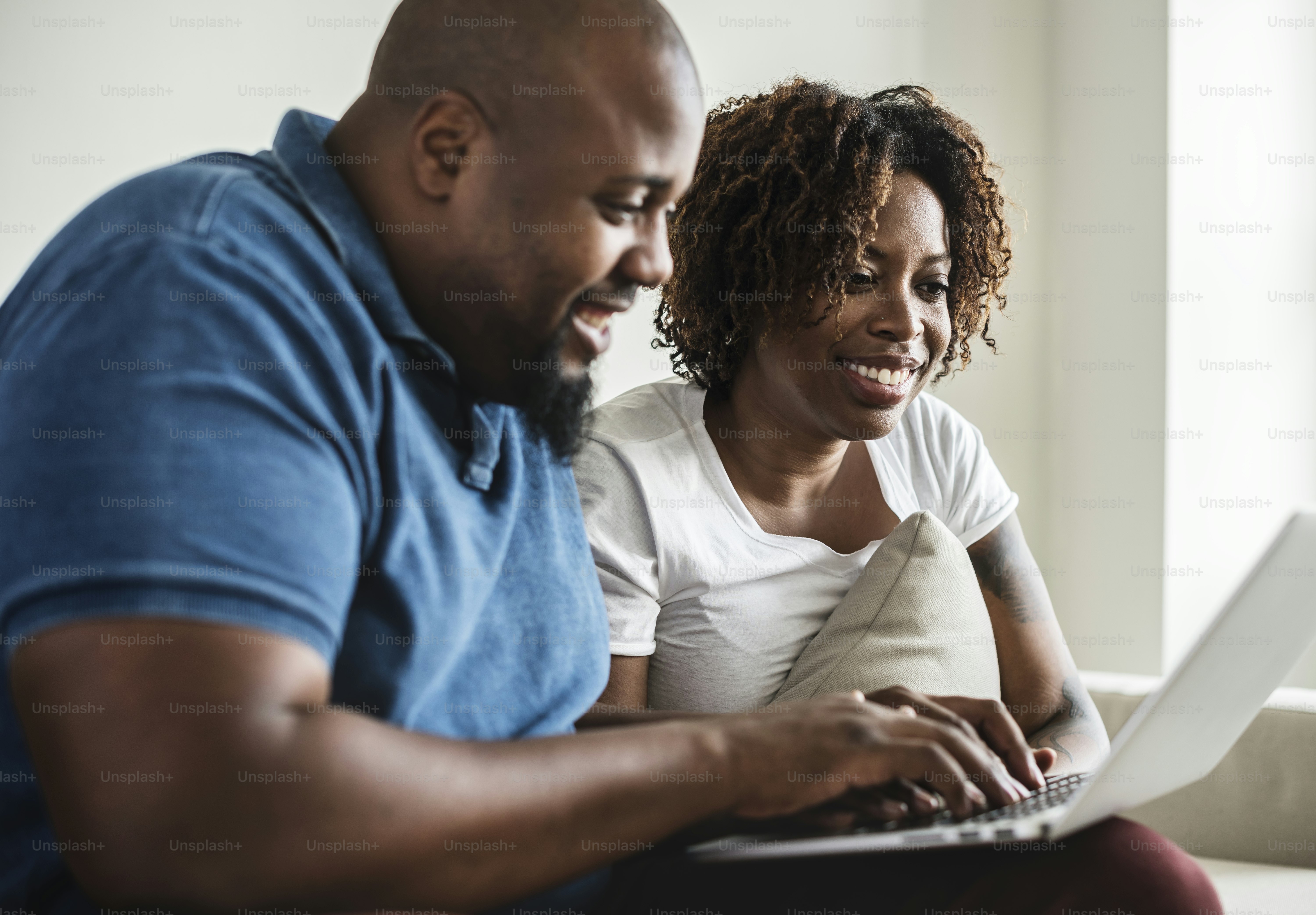 Black couple sitting together and looking at a laptop screen