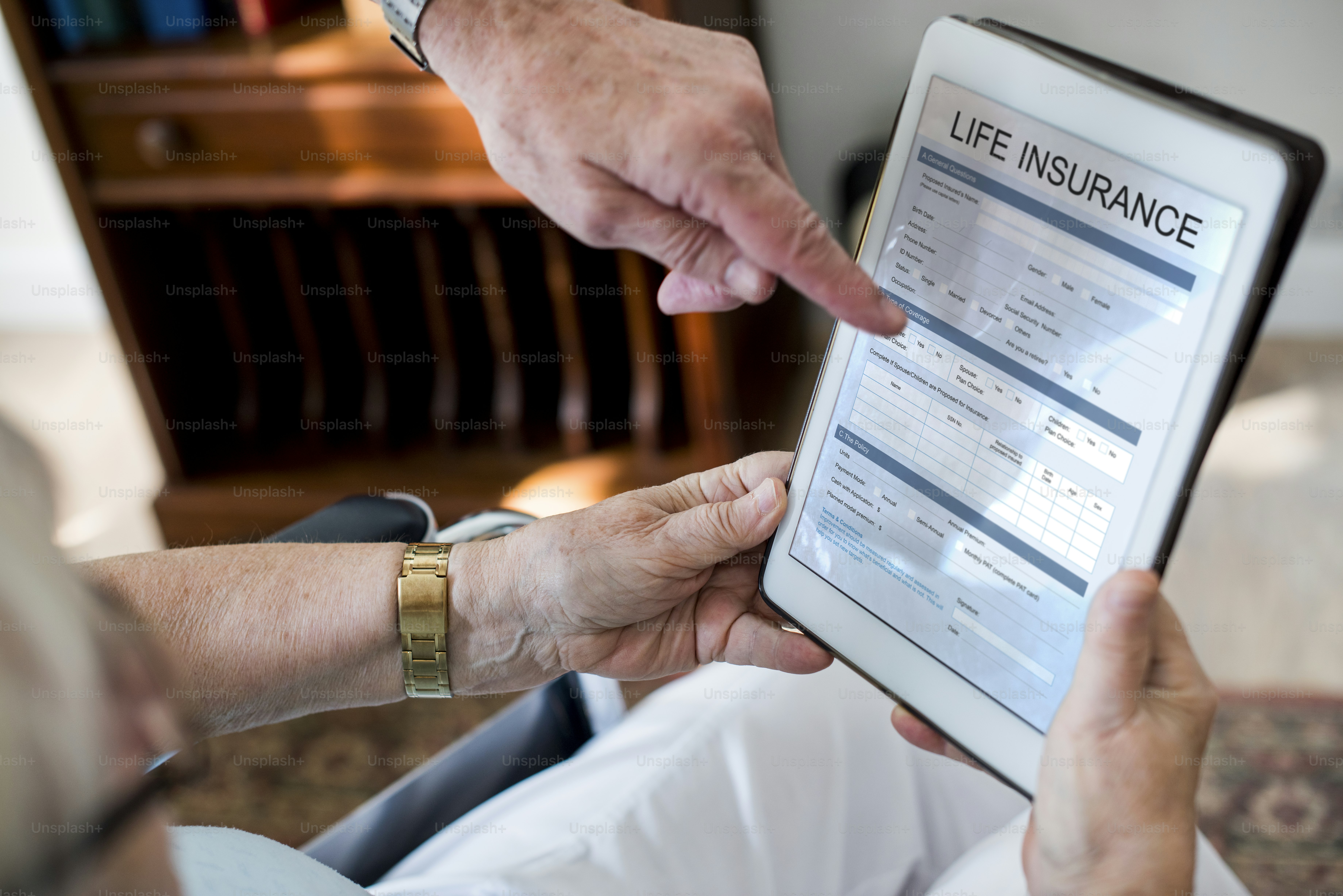 Senior couple reading life insurance form in tablet ***The screen is derived from our own designs. They do not infringe on any copyright design.