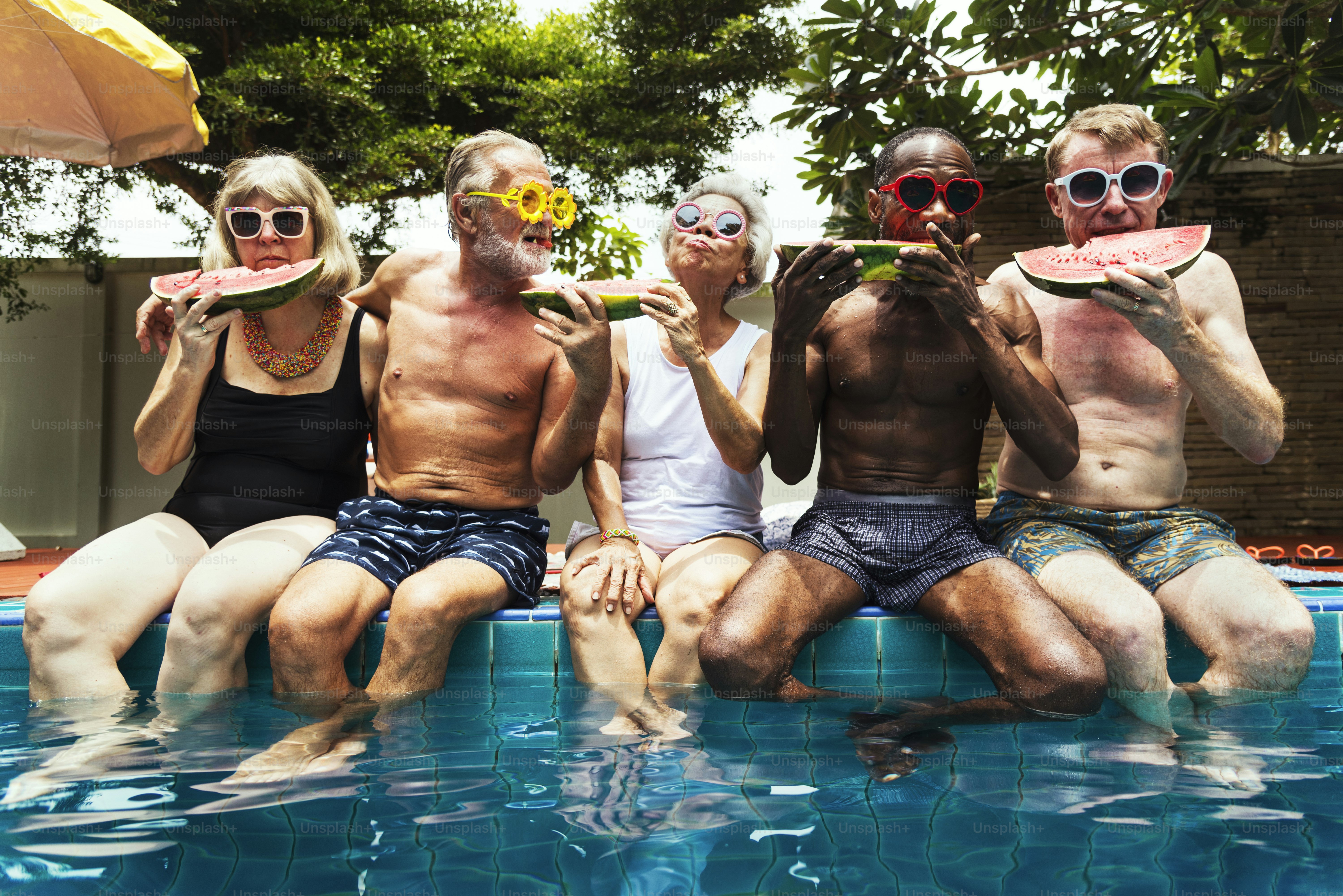 Gruppe von verschiedenen älteren Erwachsenen, die gemeinsam Wassermelone essen