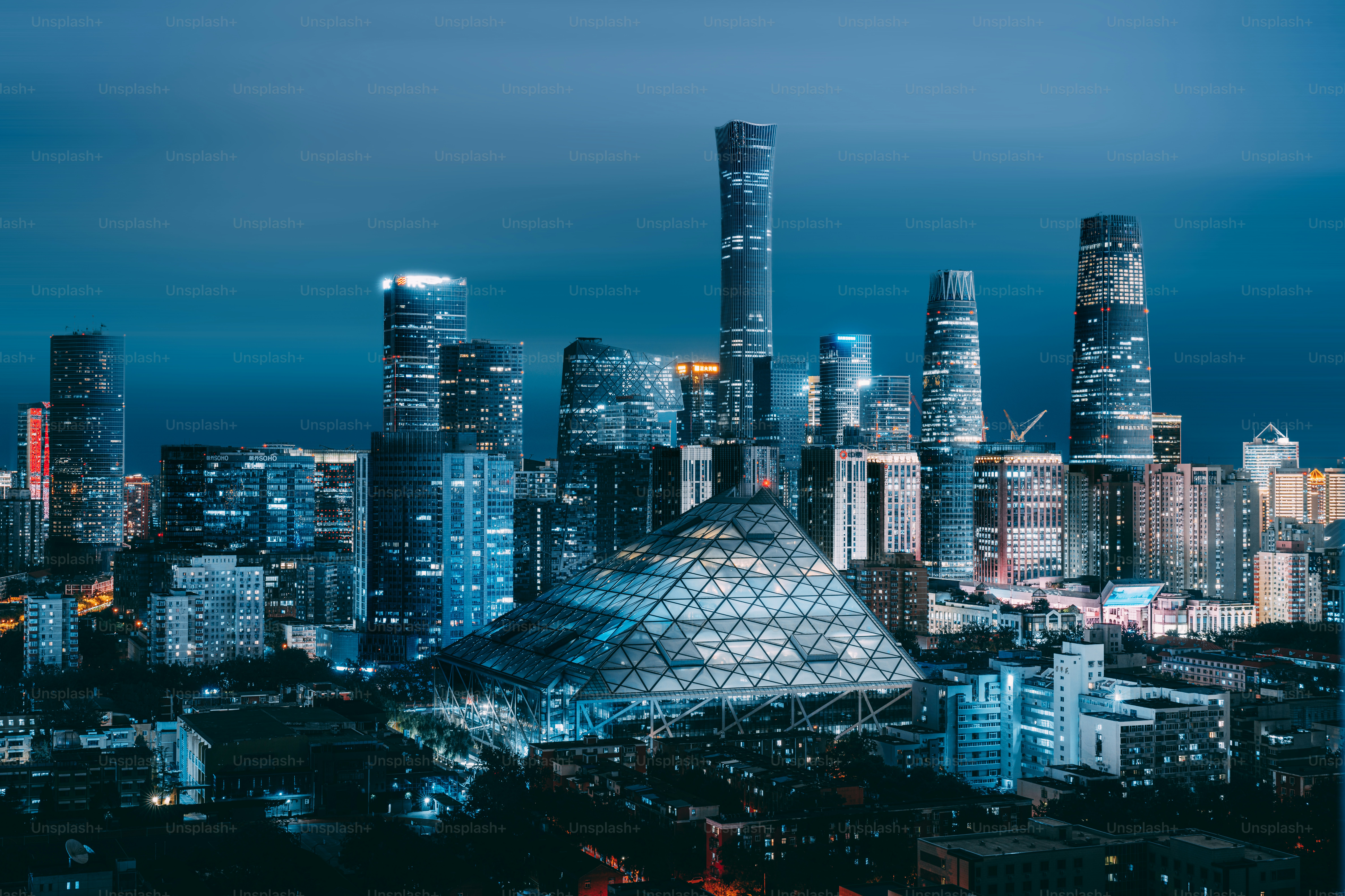 A view of a city at night from the top of a hill