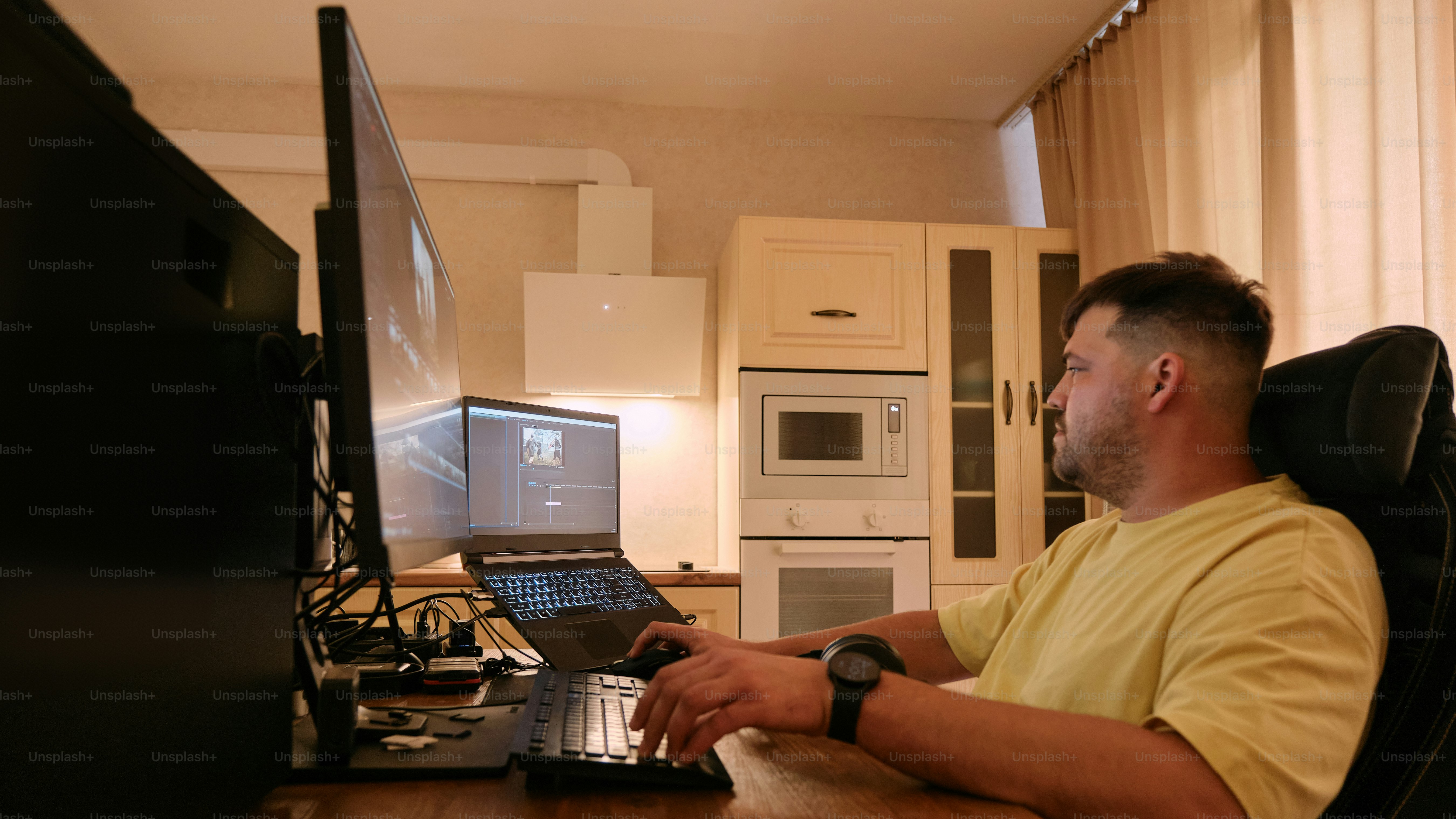 A man sitting at a desk using a laptop computer