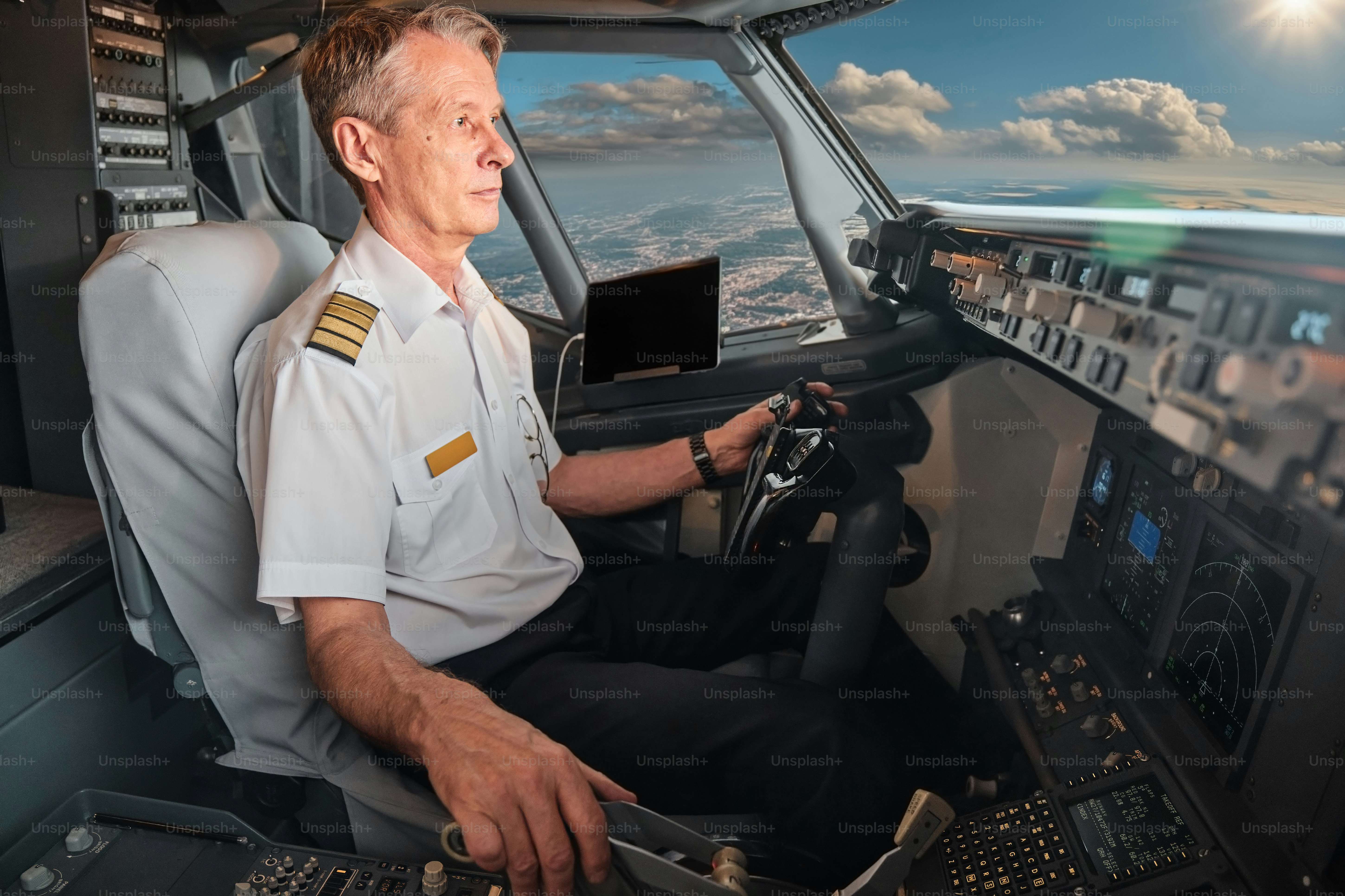 a pilot at work in the cockpit of a passenger airliner