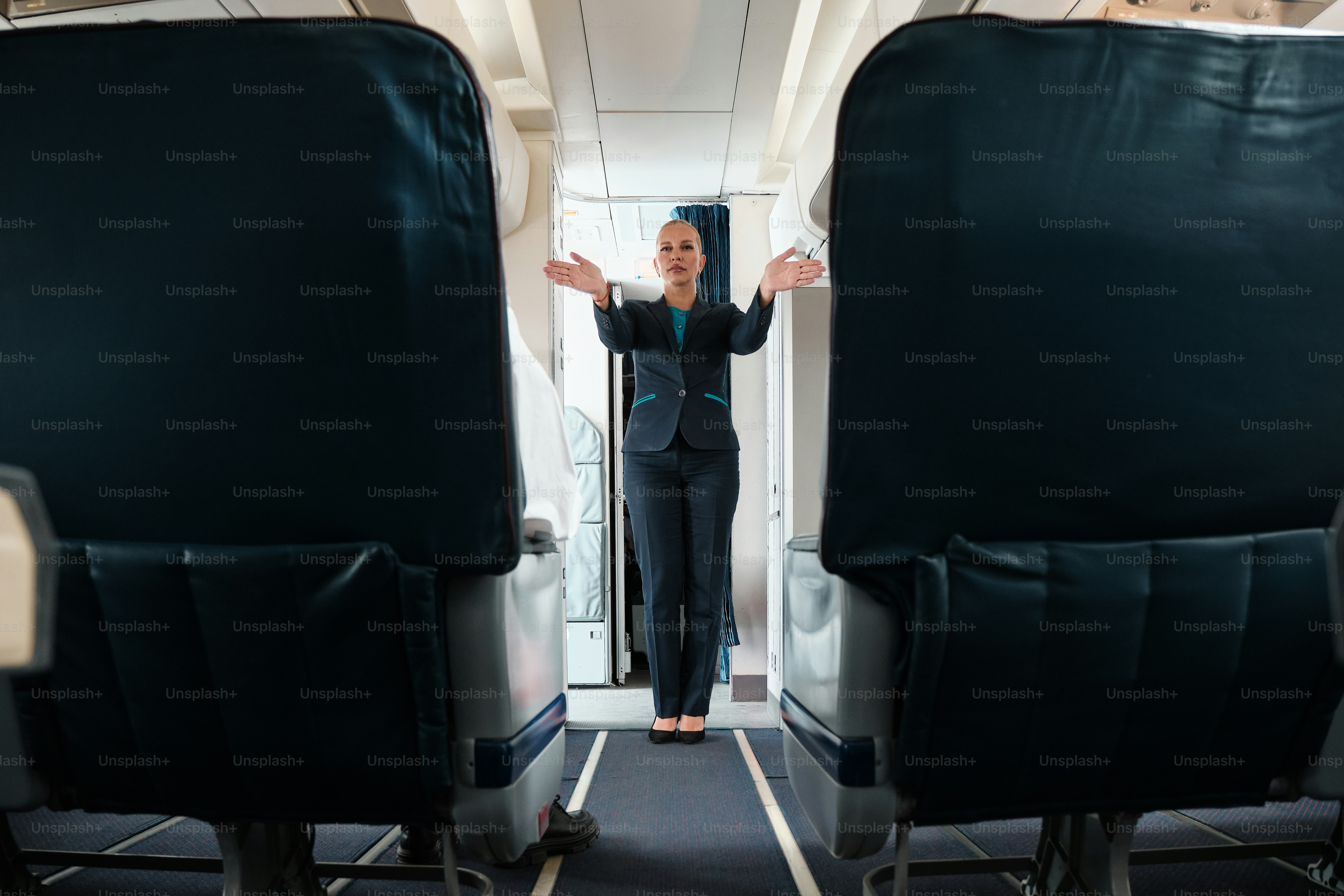 A woman standing on an airplane with her arms outstretched