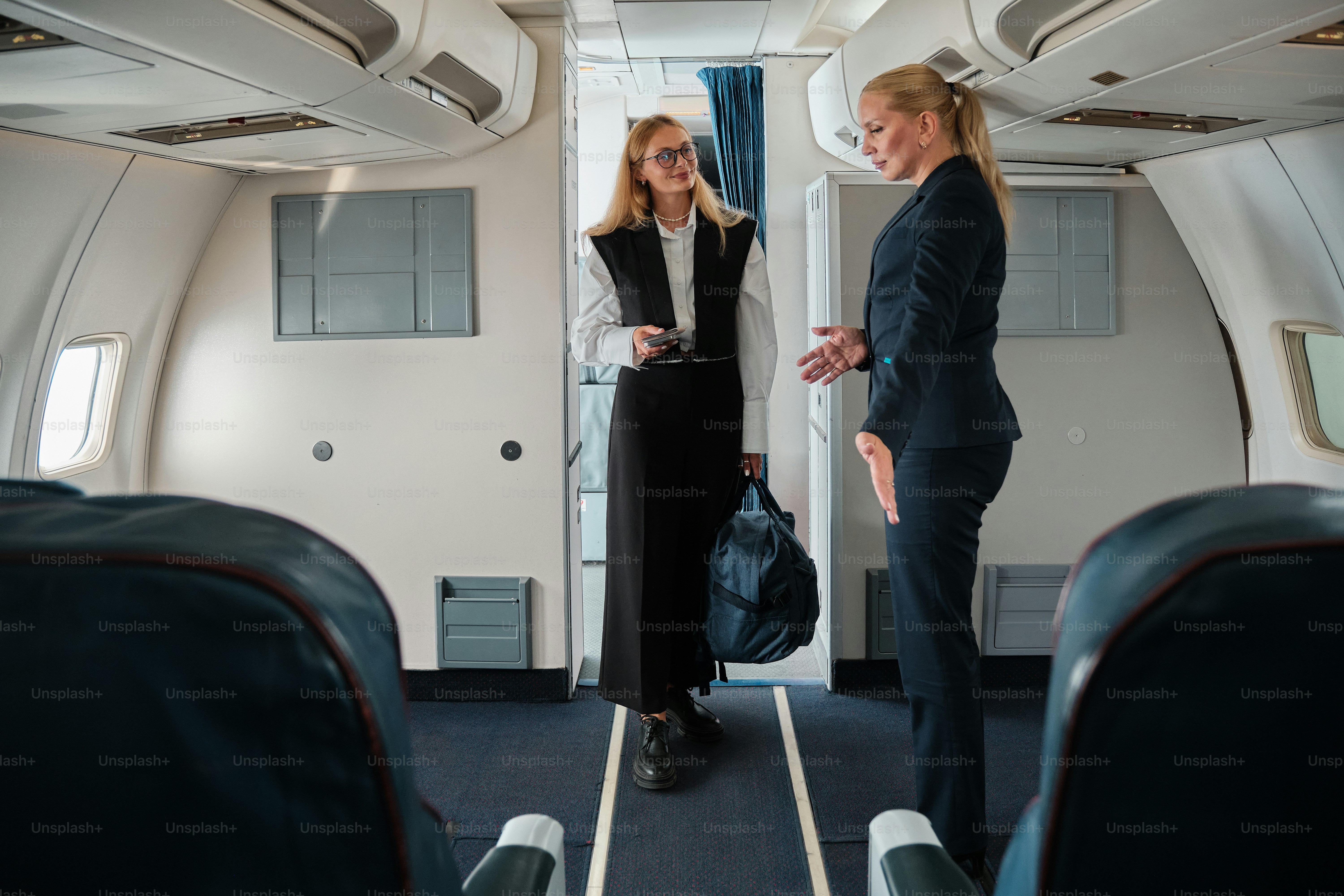 A couple of women standing on top of an airplane