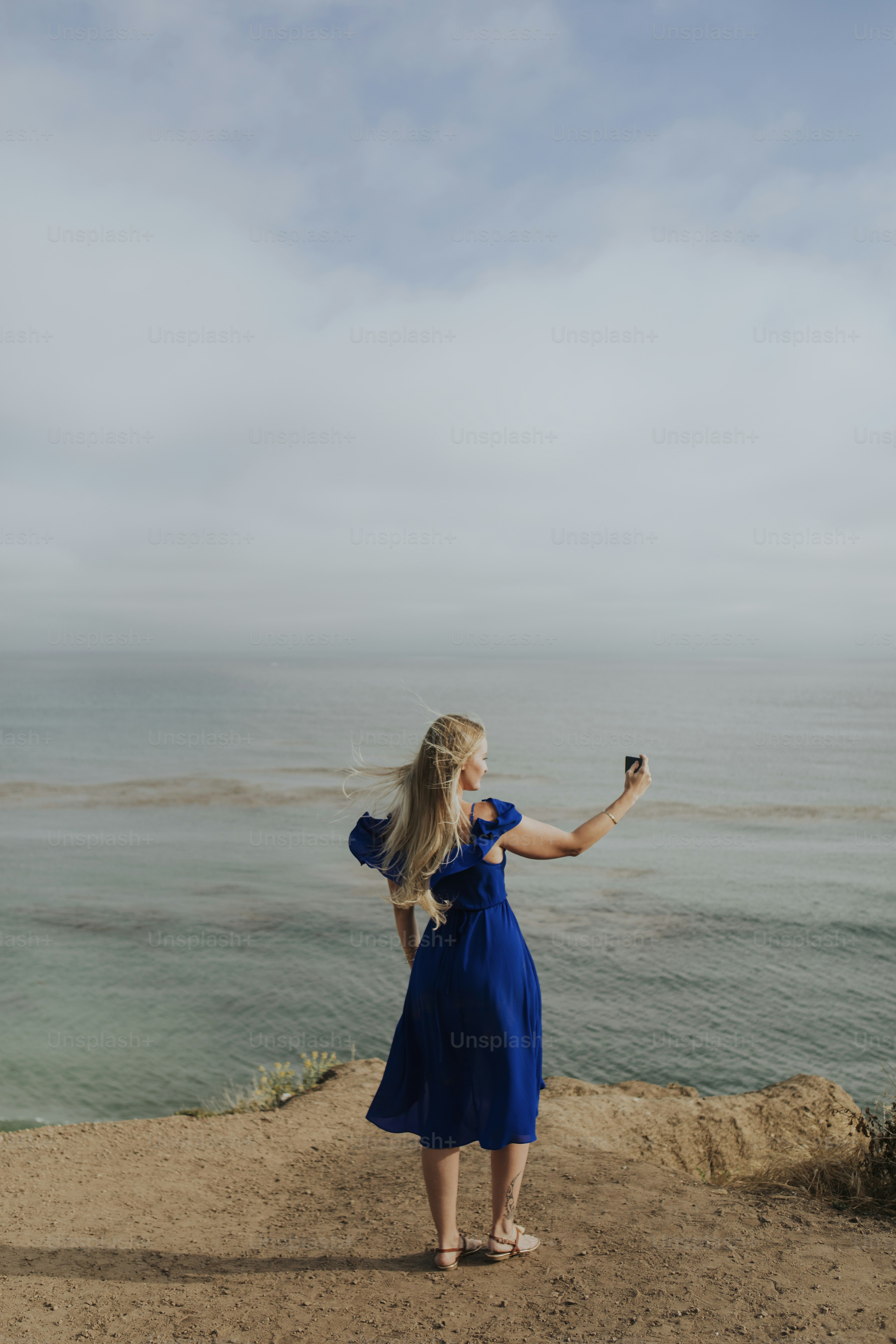 Eine blonde Frau, die ein Foto mit einem Handy macht