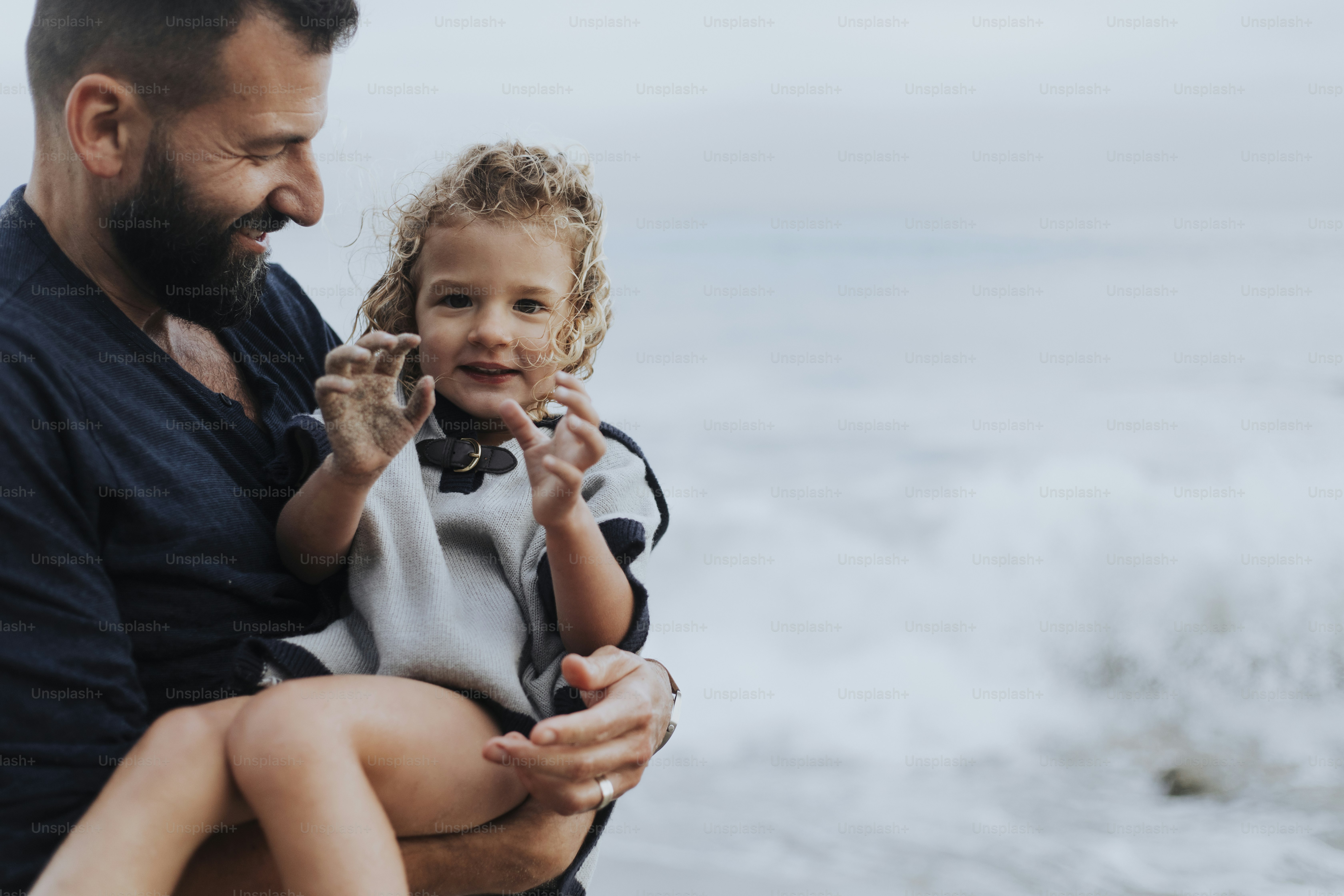 Dad carrying her playful daughter photo – Beach Image on Unsplash