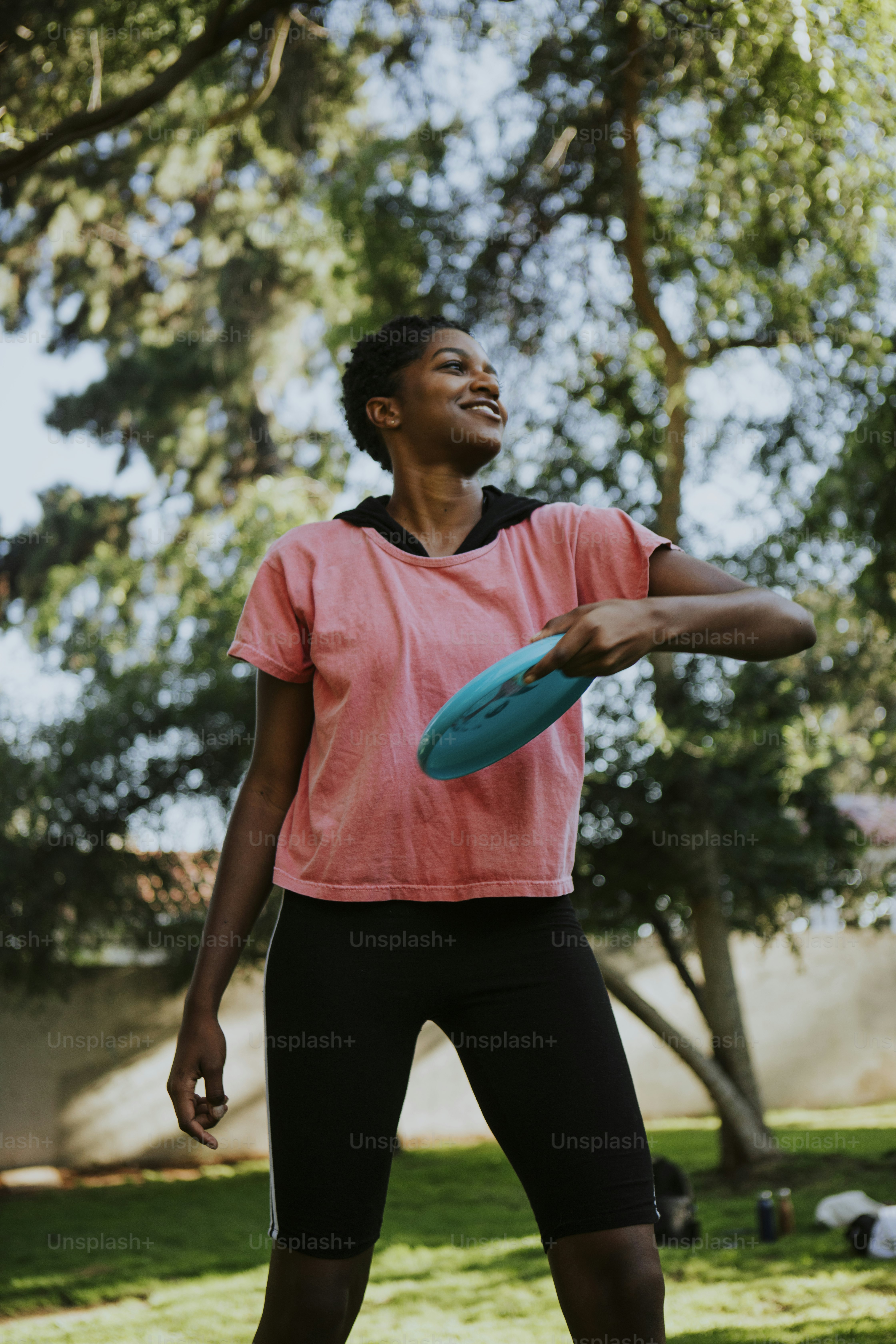 Femme active lançant un frisbee dans le parc