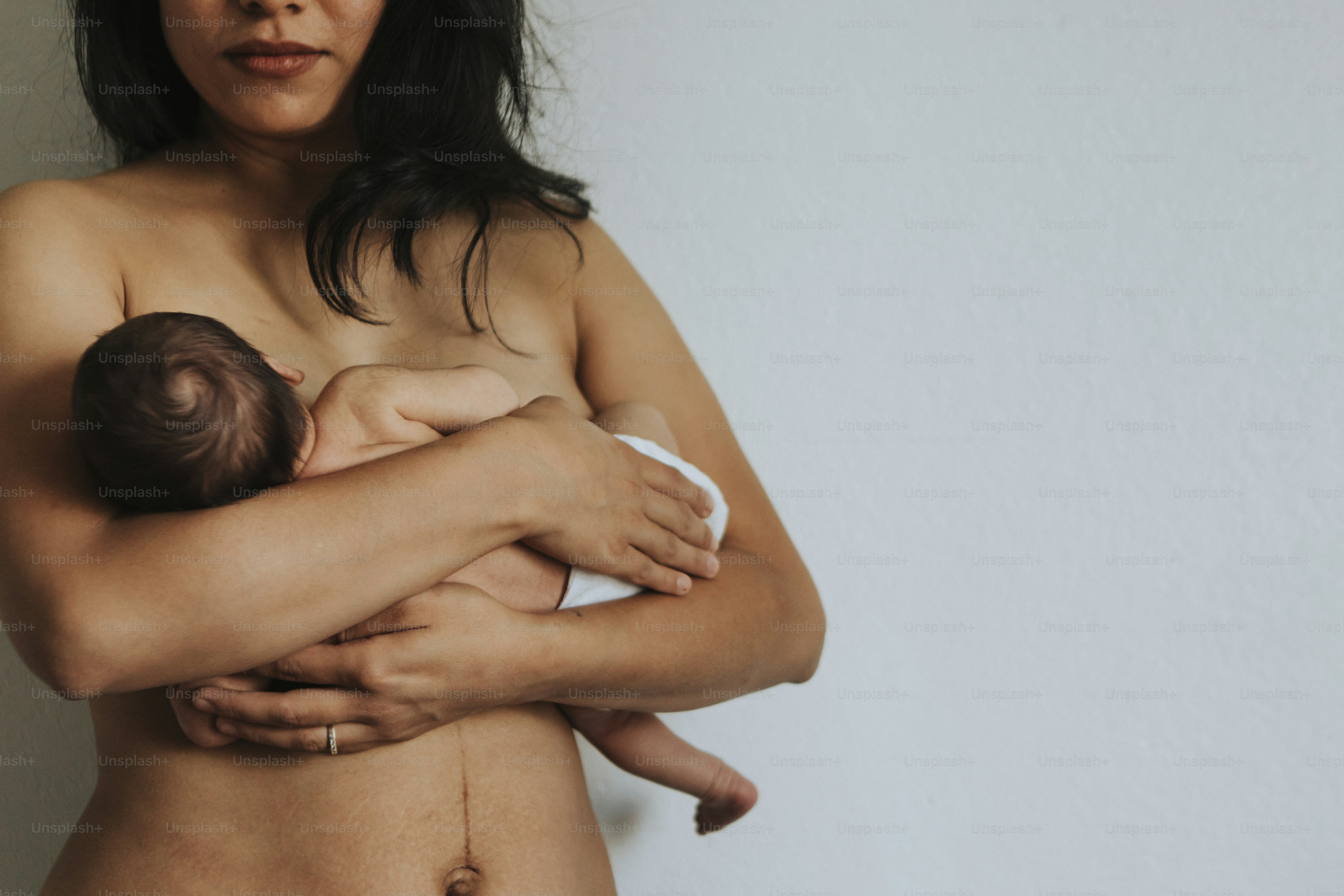 Naked mother holding her infant baby