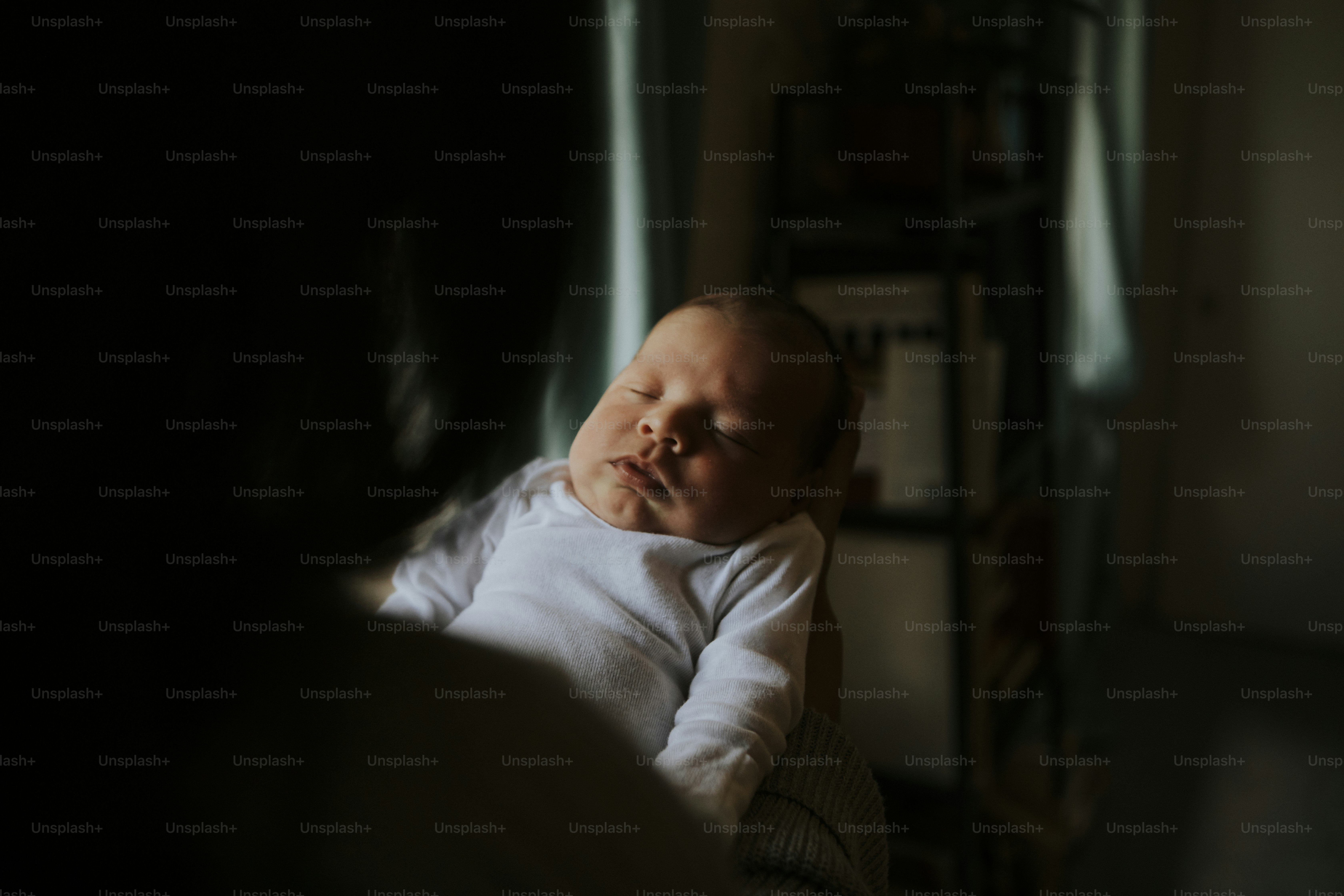 Mother holding her baby indoors