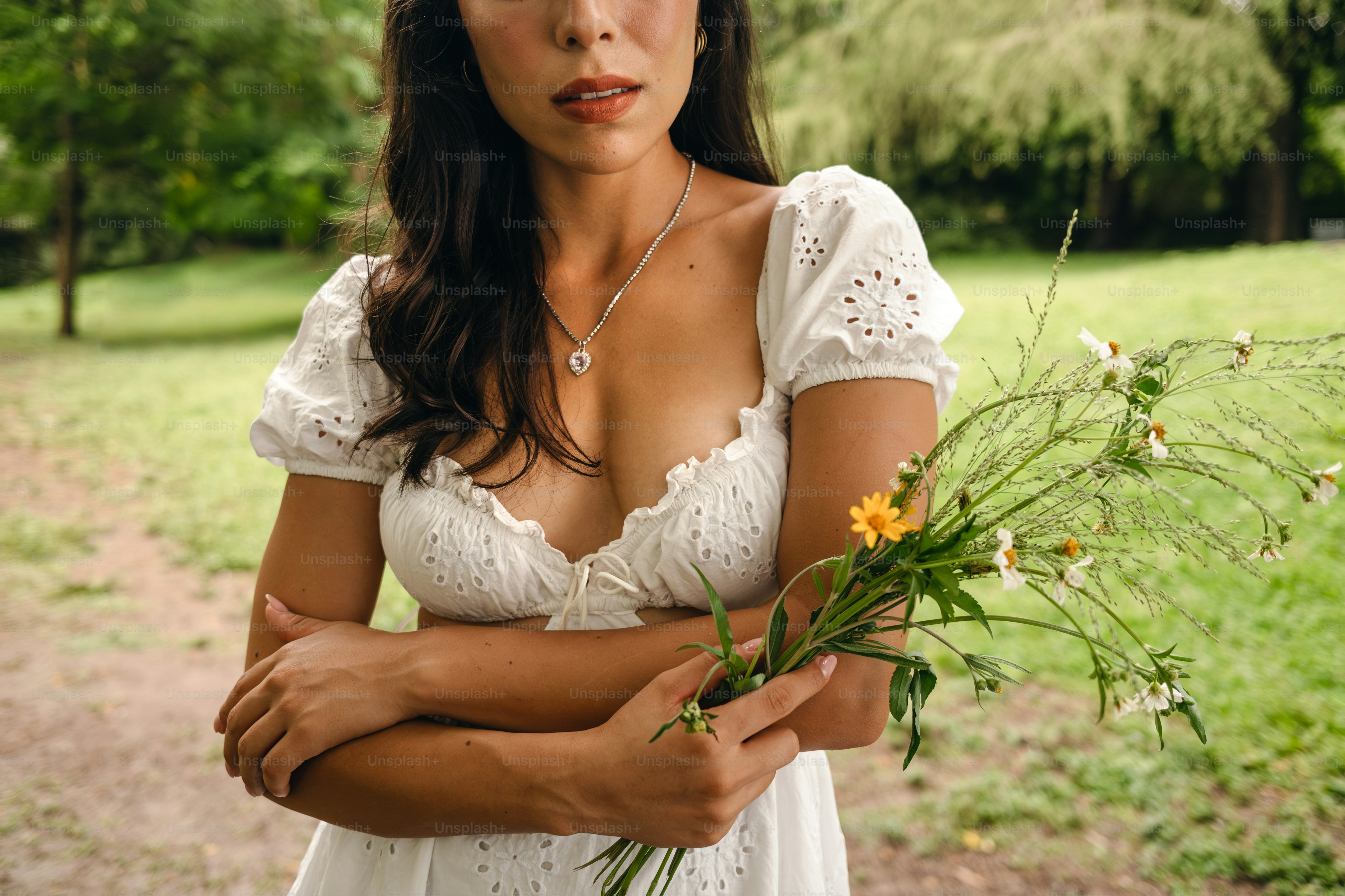 A woman in a white dress holding a bouquet of flowers