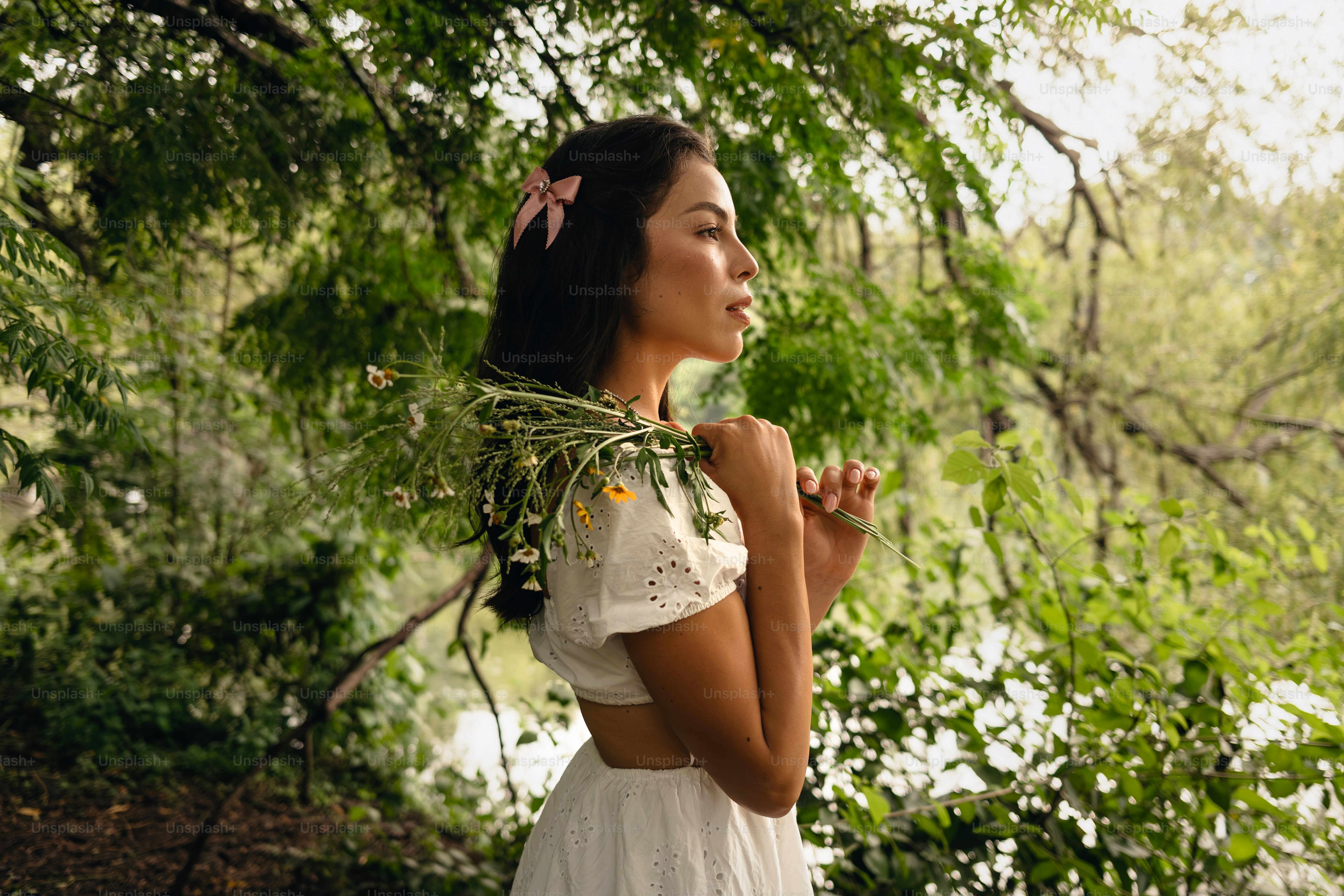 A woman in a white dress standing in a forest