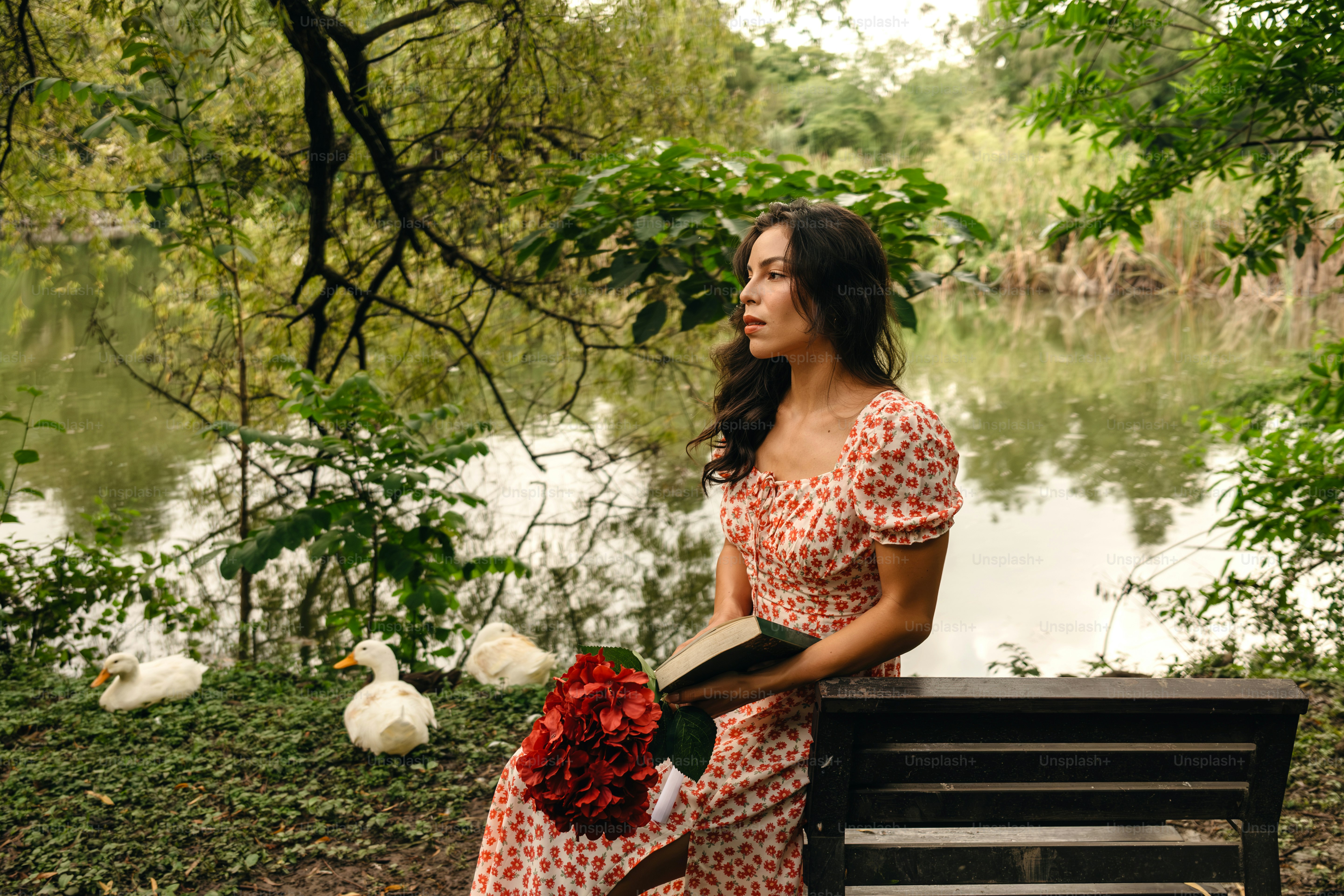 A woman sitting on a bench next to a lake