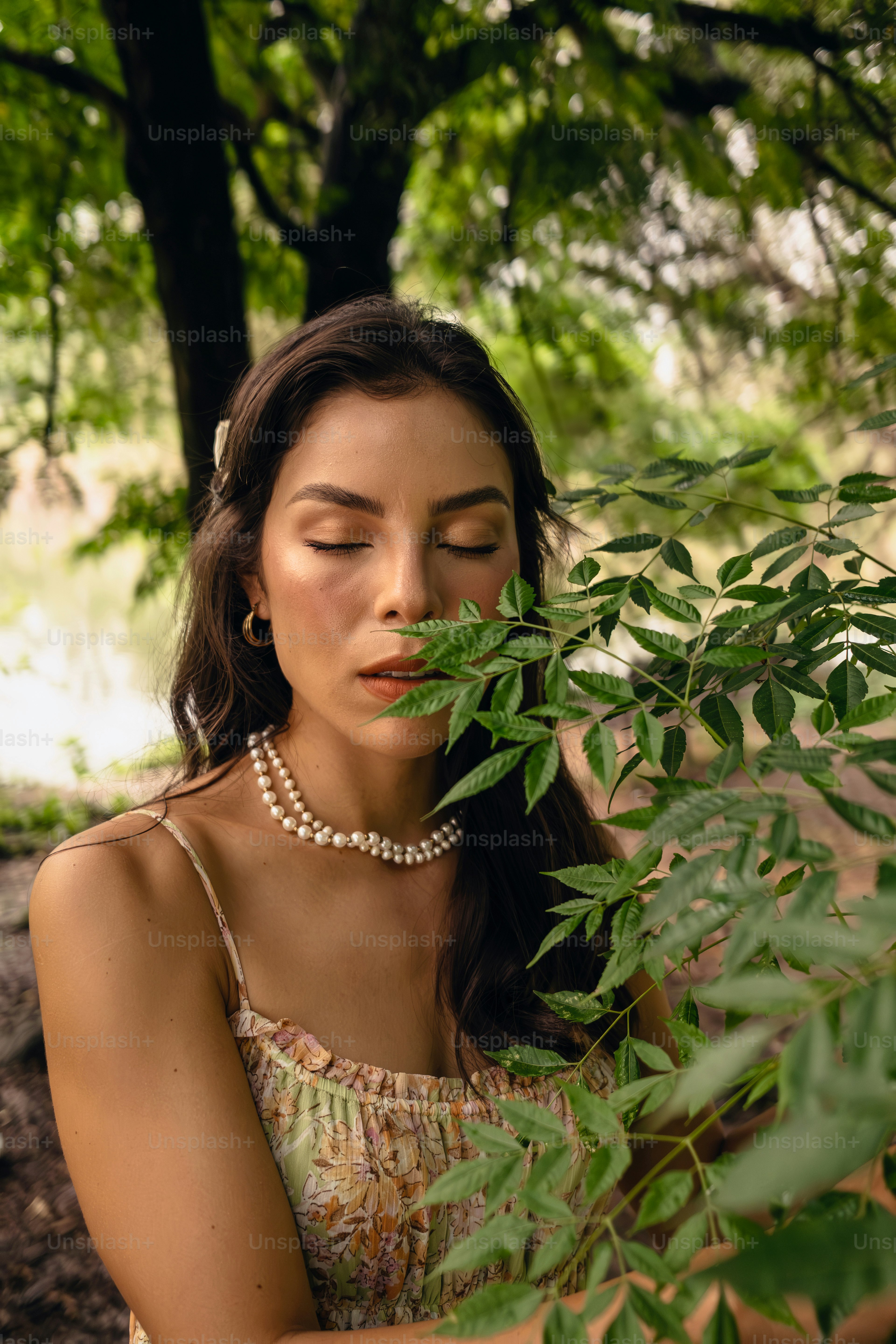 A woman in a dress is holding a plant