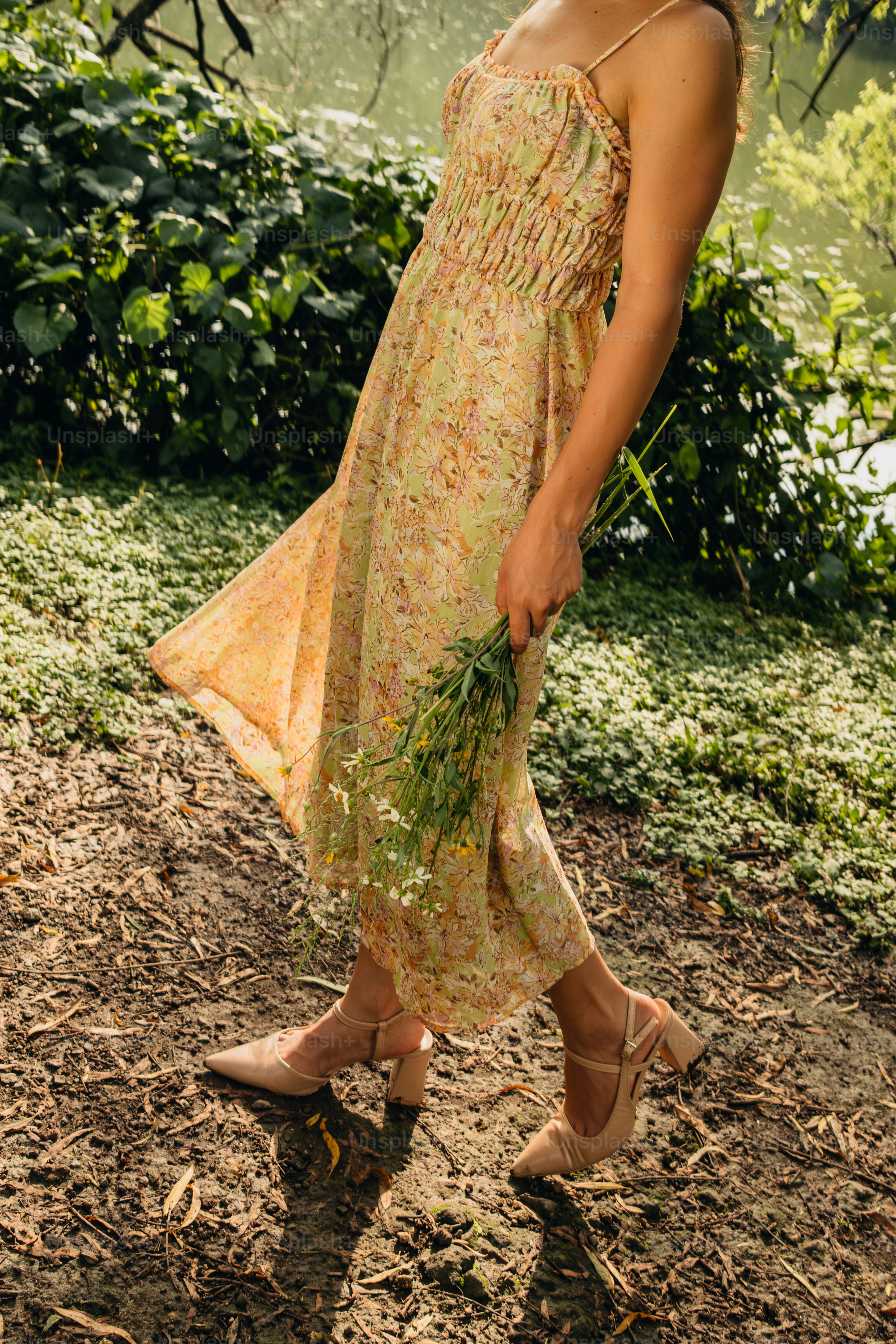 A woman in a dress holding a bunch of flowers