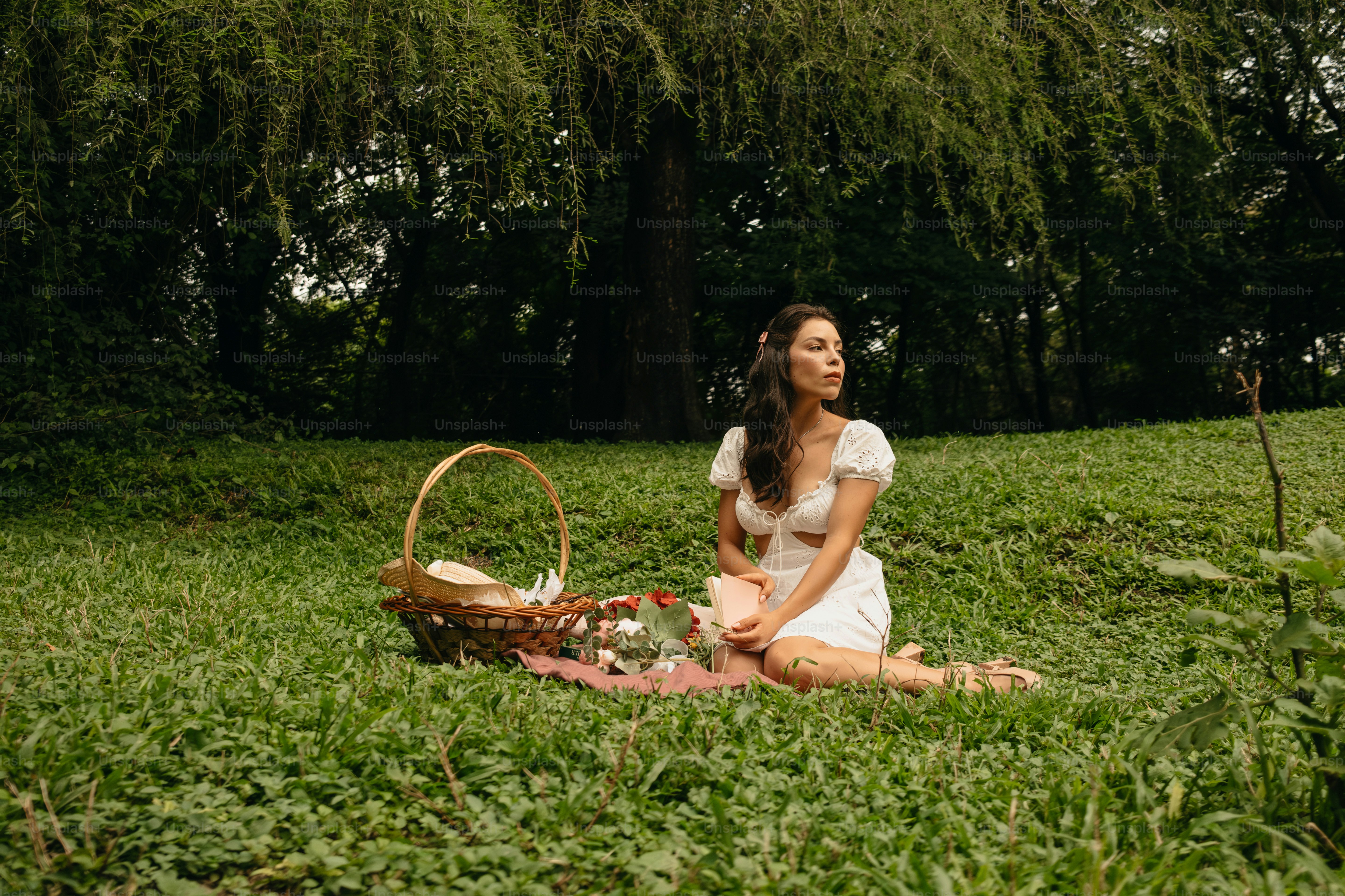 A woman sitting in the grass with a basket