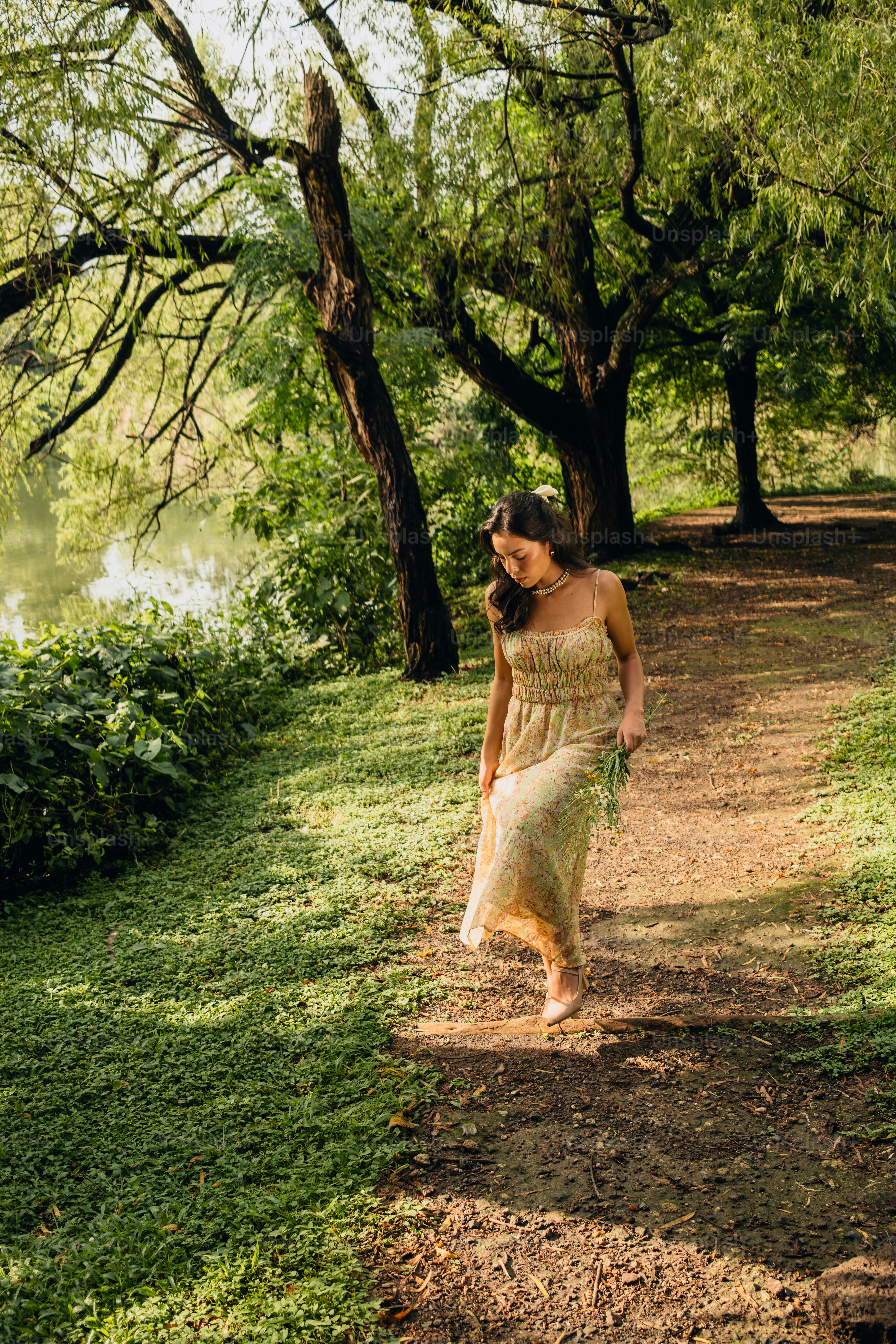 A woman in a dress walking down a path