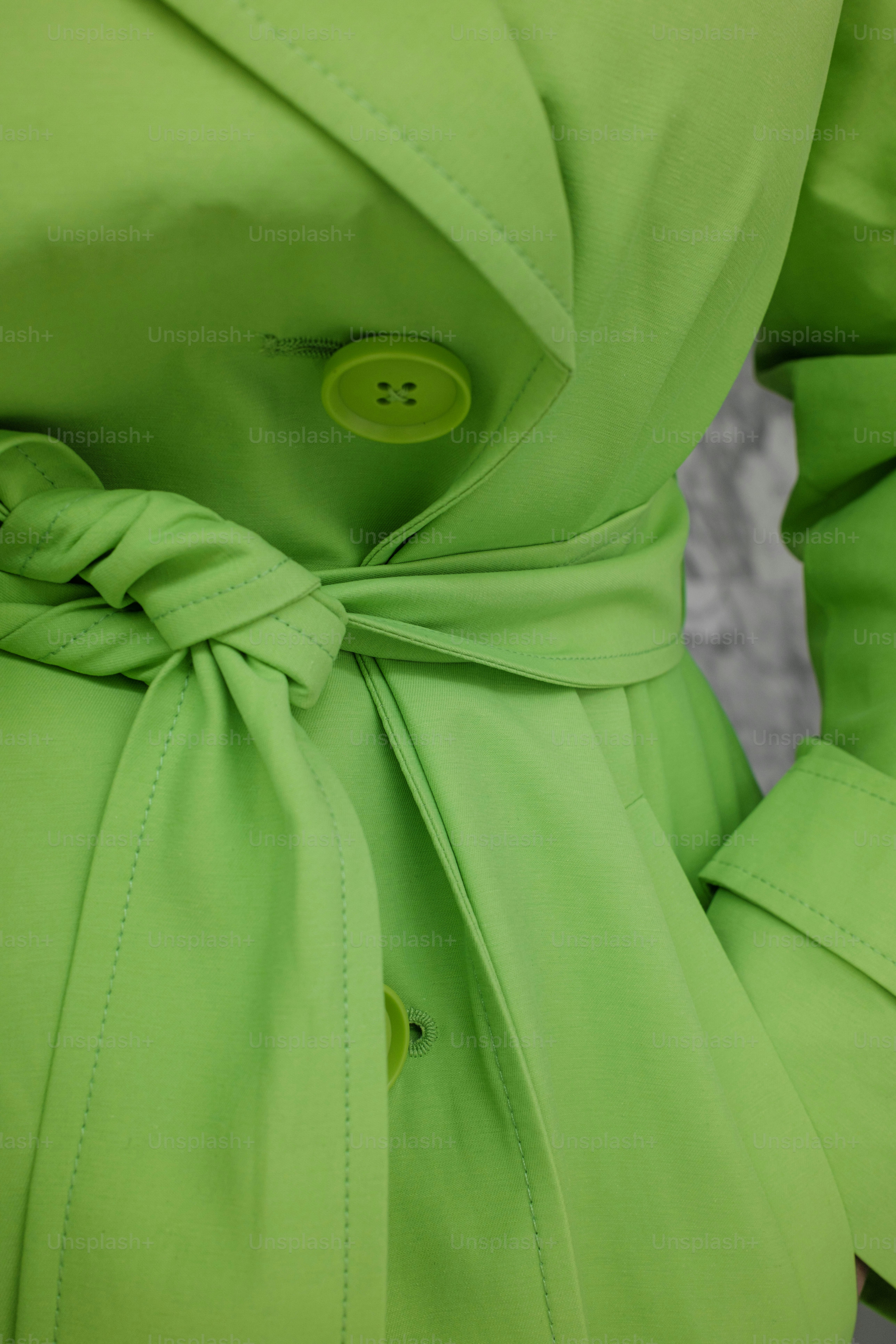 Une femme portant un manteau vert avec un bouton vert