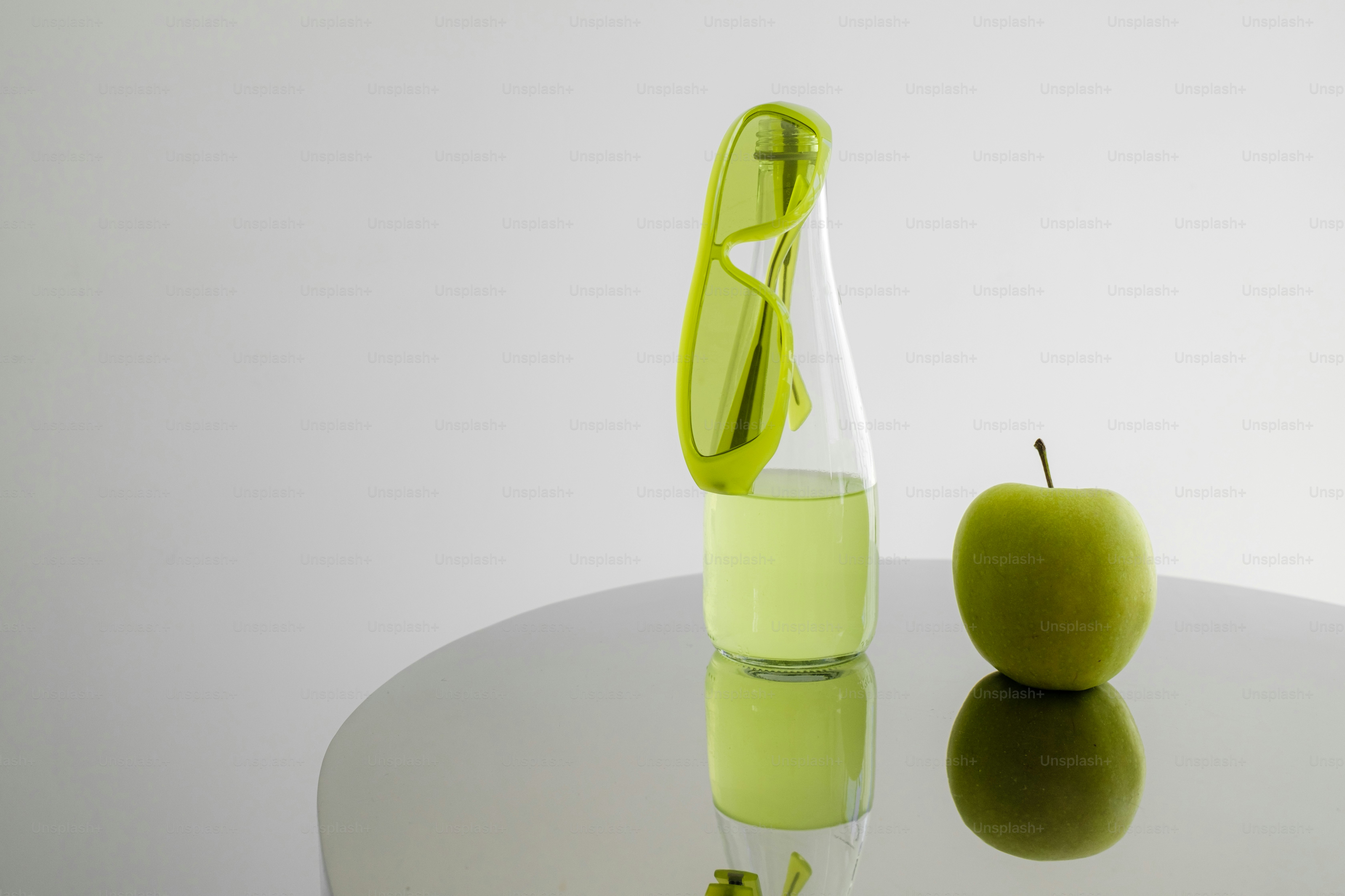 A green apple sitting on top of a white table