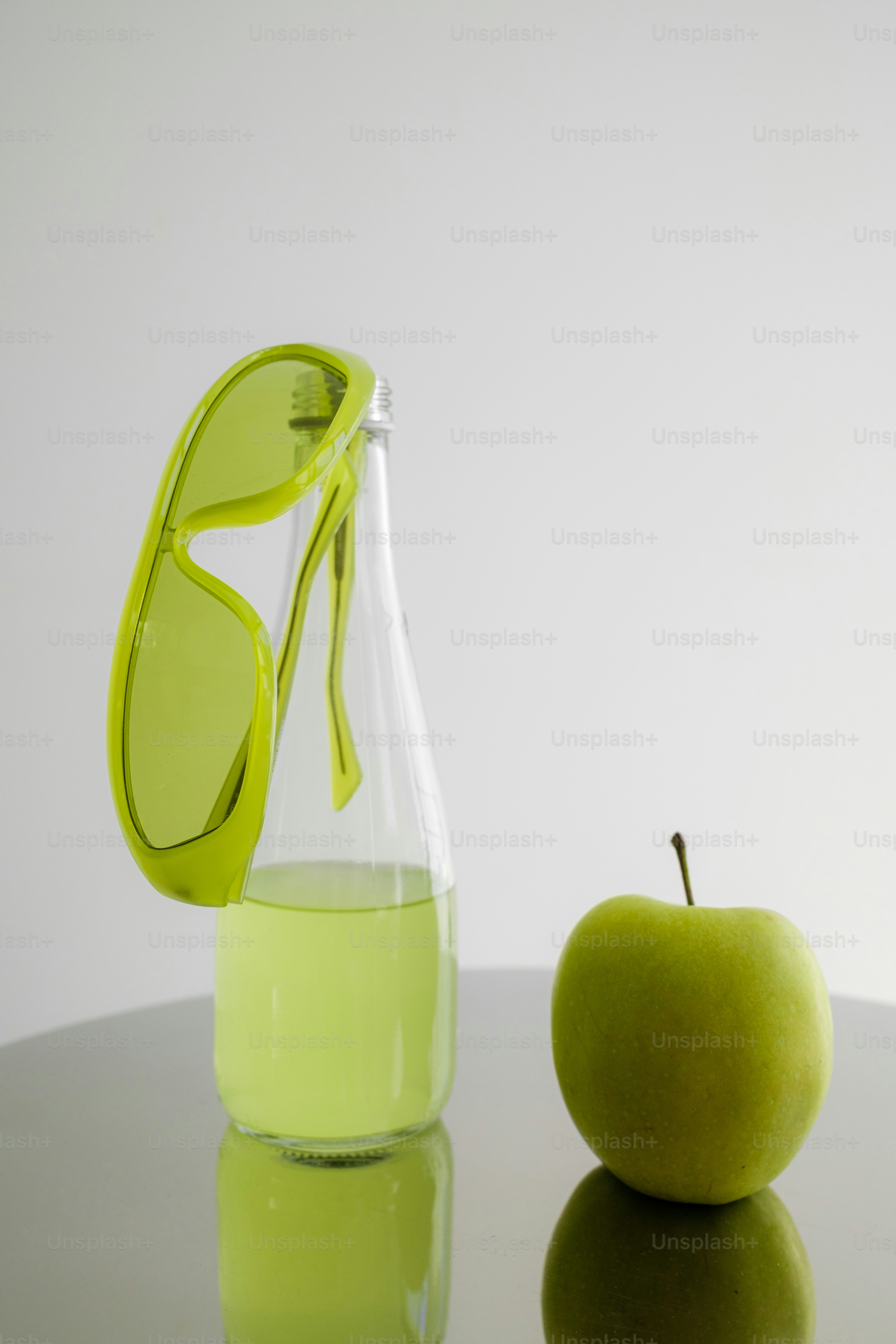 A green apple sitting next to a glass of water
