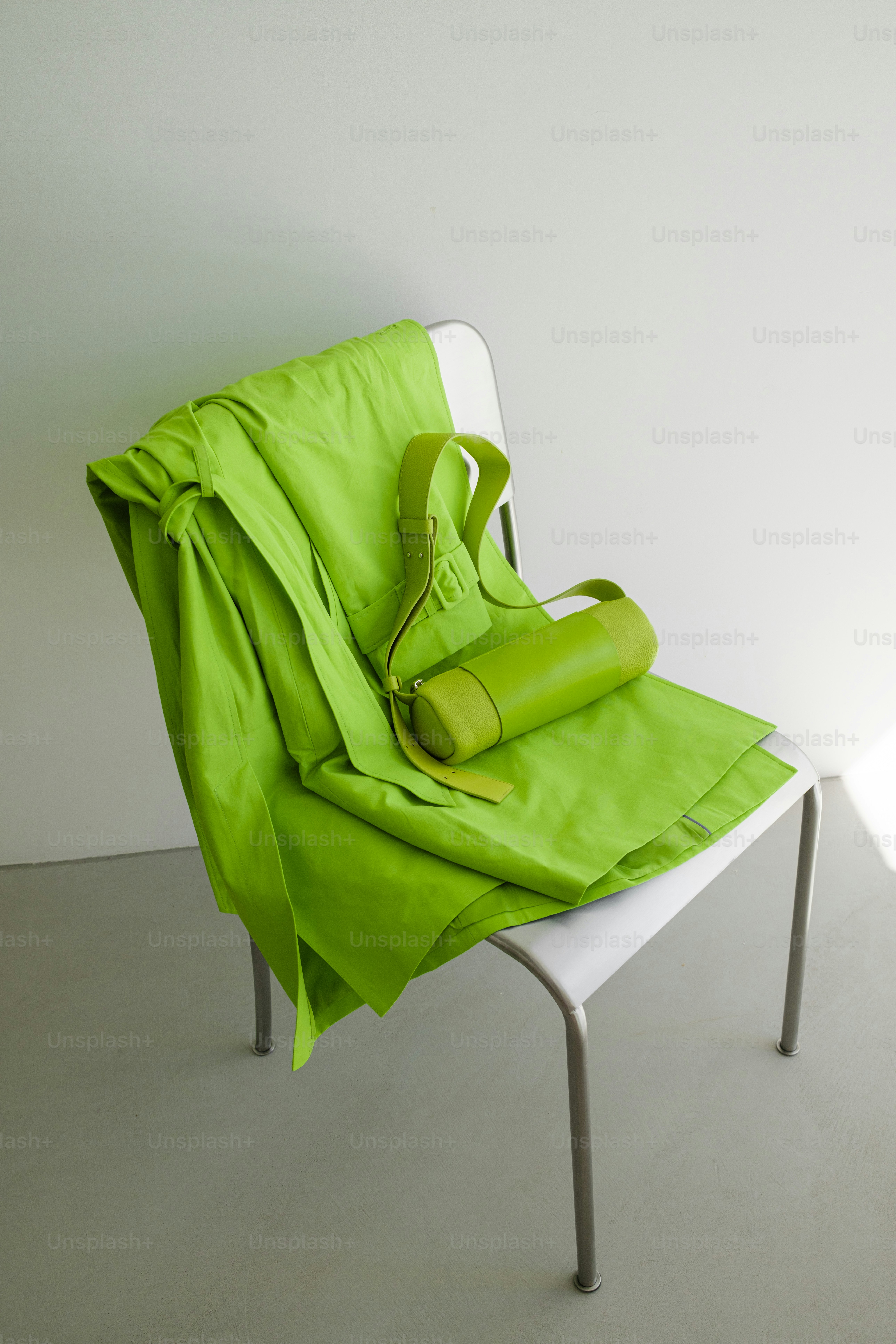 A green blanket sitting on top of a white chair