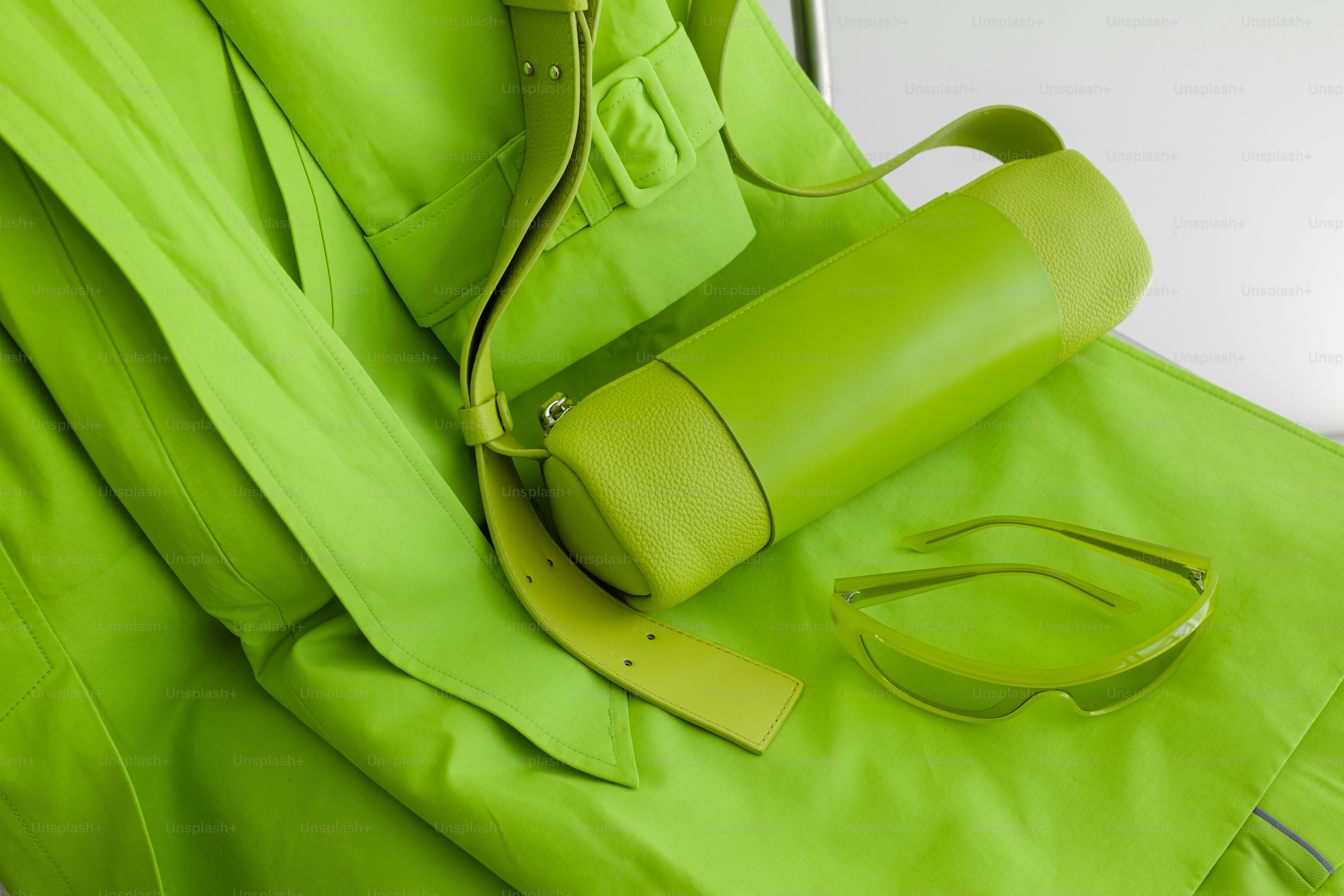 A green bag with a handle and strap