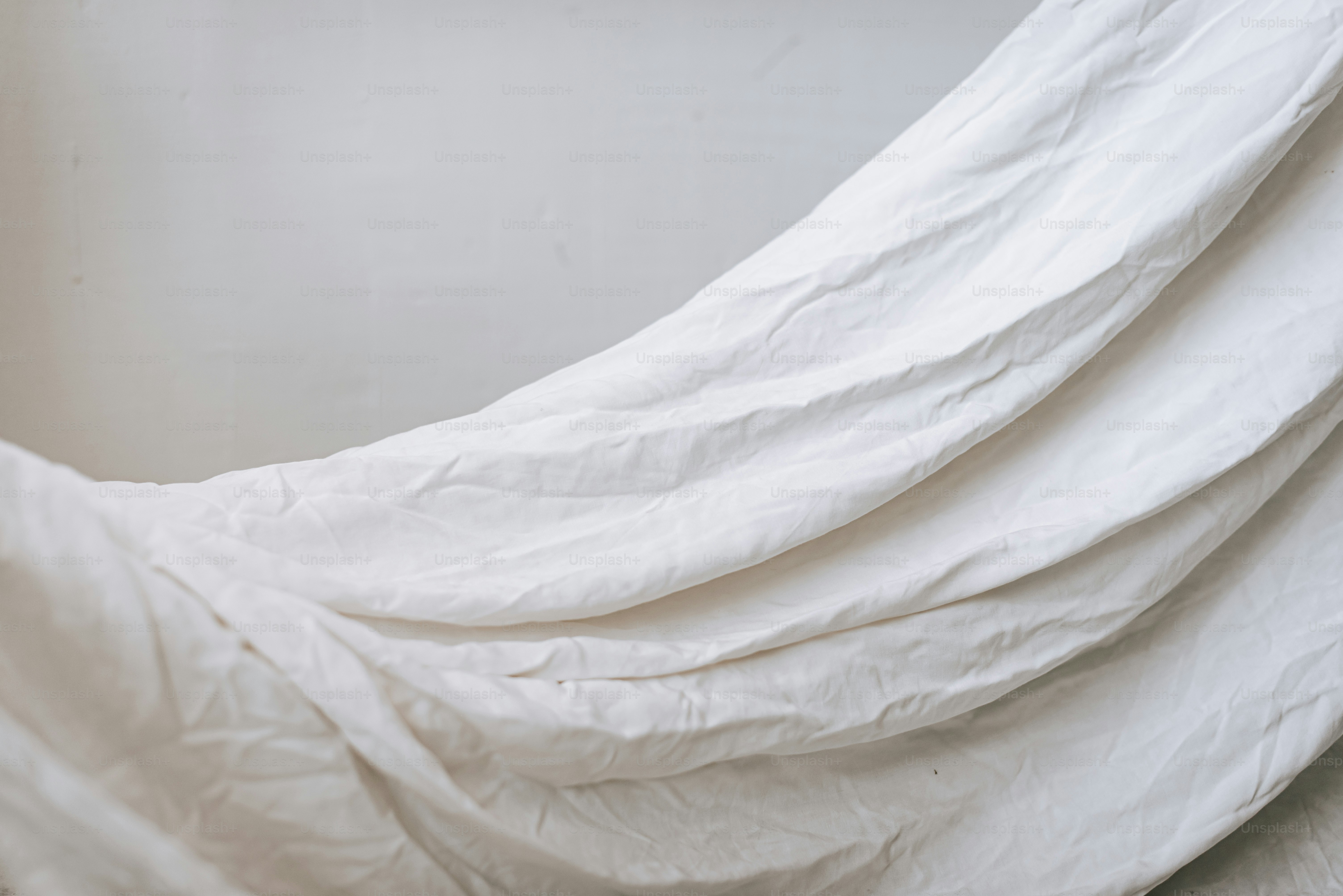 Ein weißes Bett mit einer weißen Bettdecke darauf