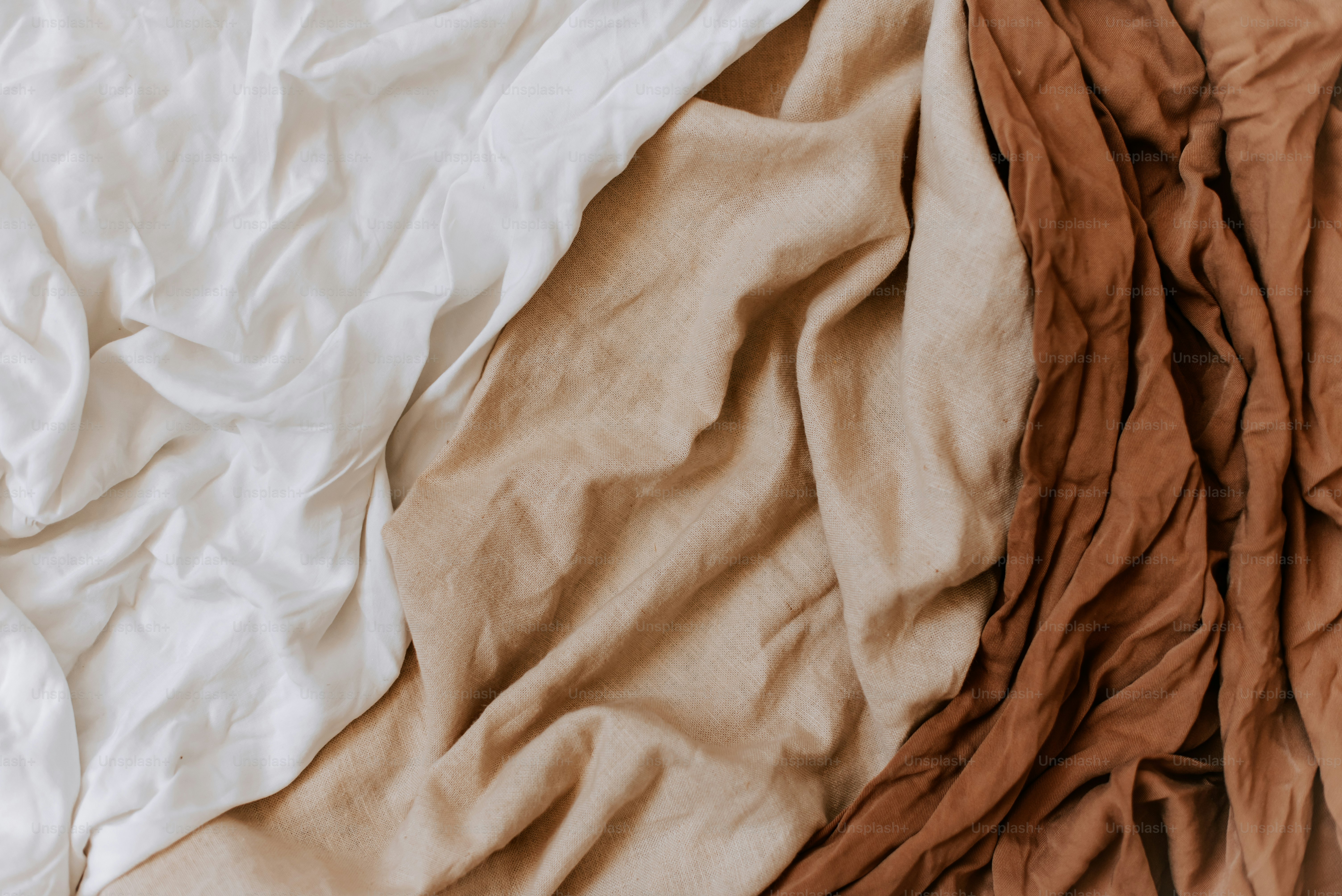 Un primer plano de una cama con sábanas y sábanas