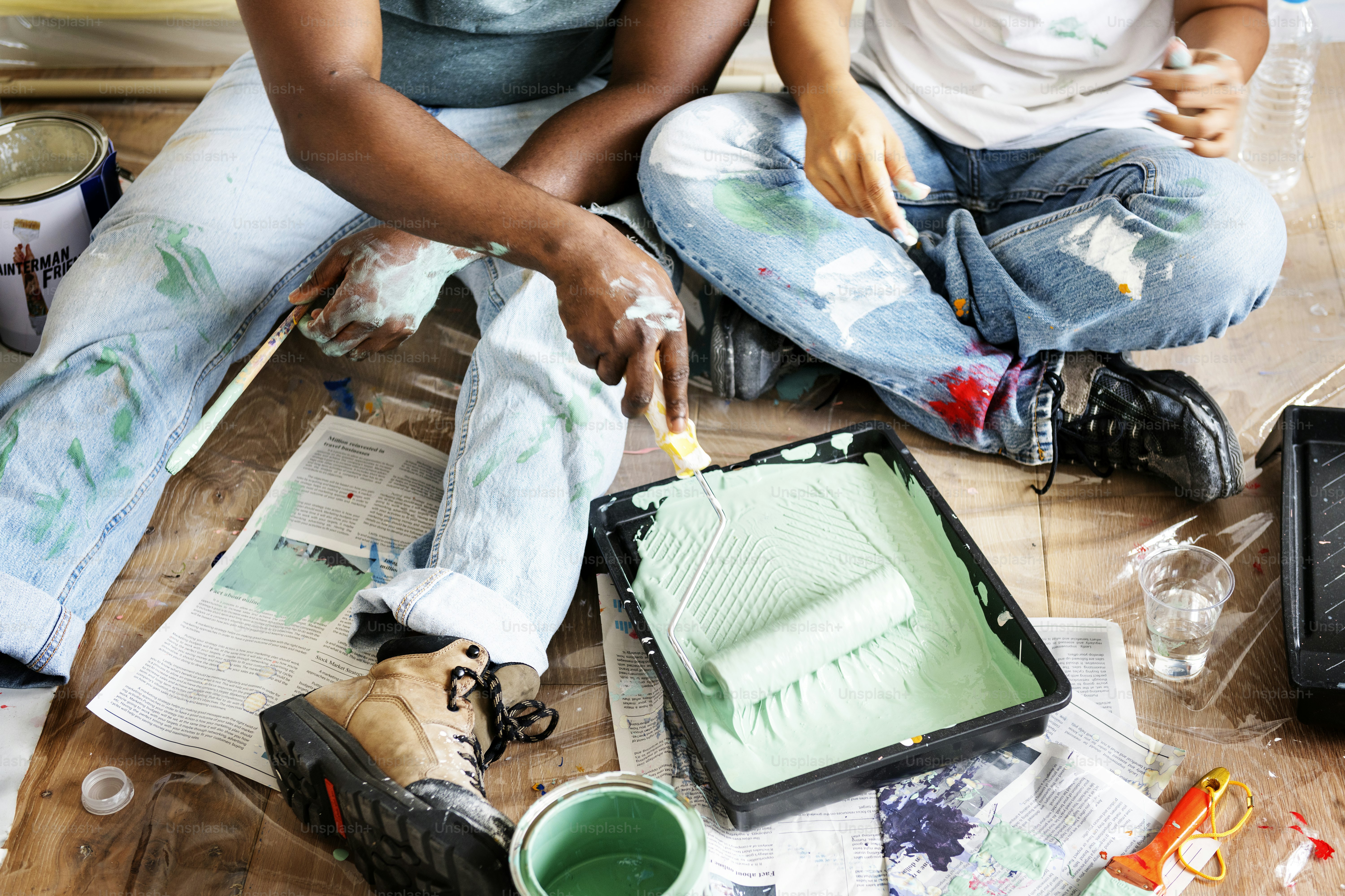 Couple painting house wall