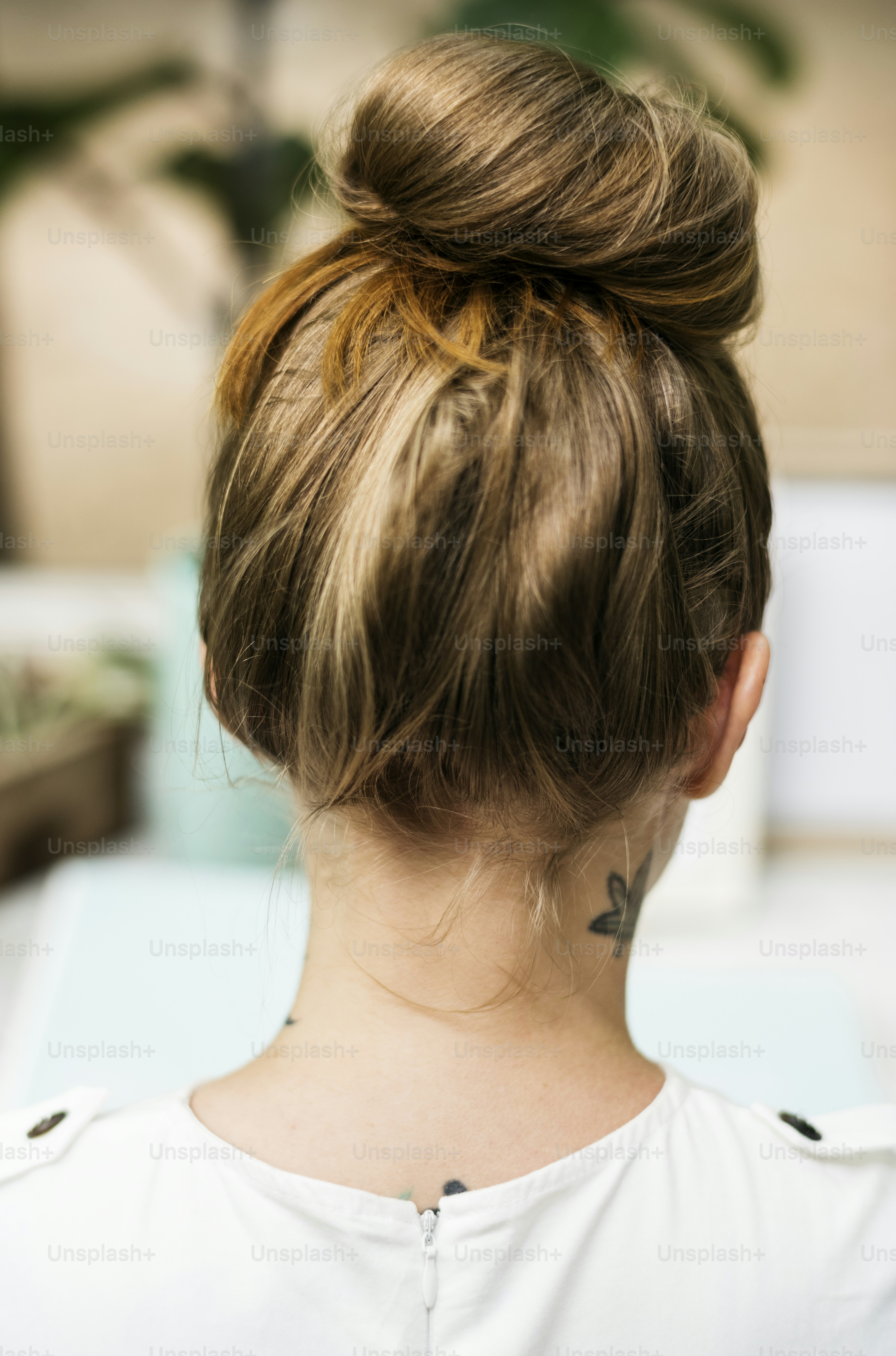 Tampilan belakang wanita dengan tato di lehernya