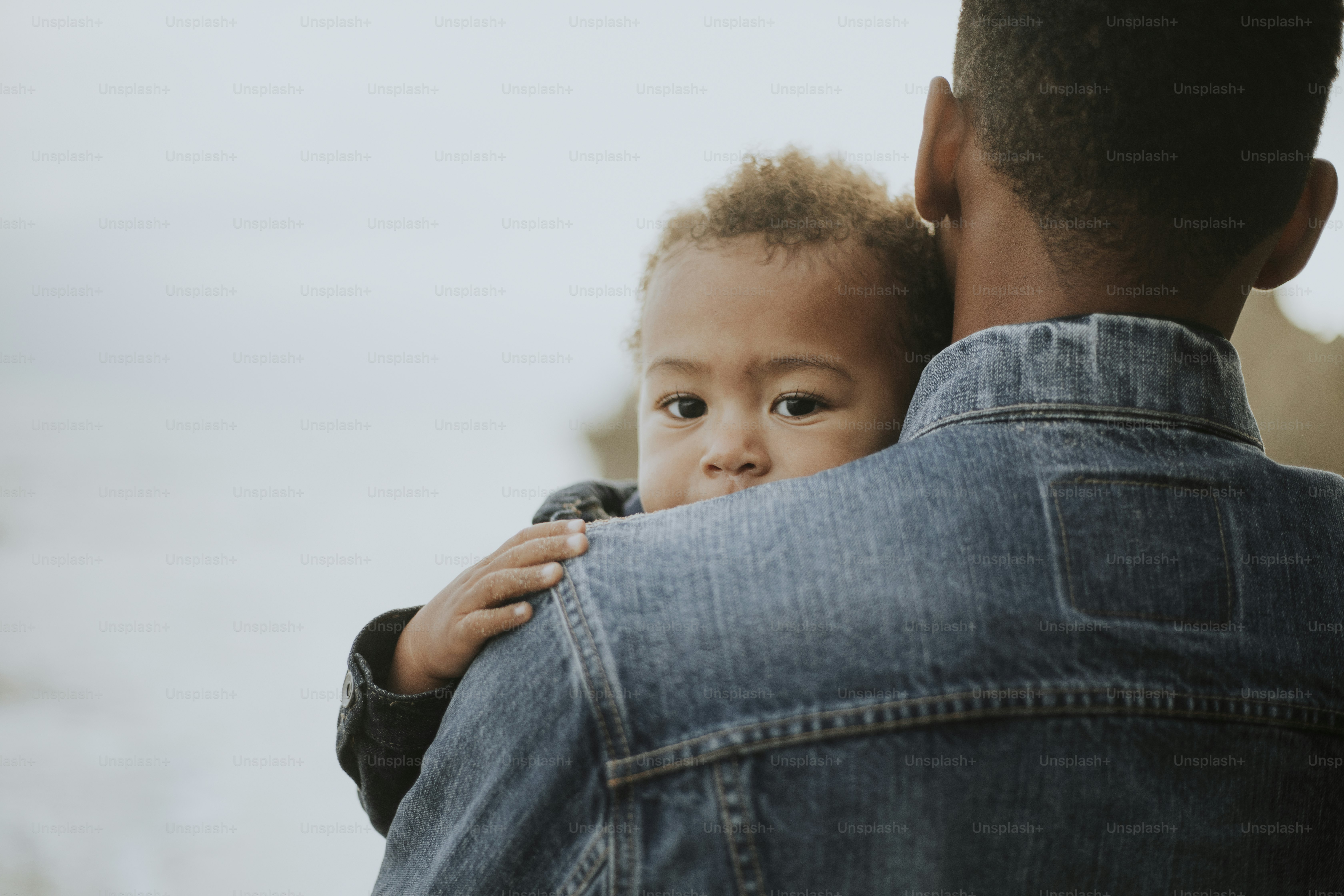 Young boy carried by his dad outdoors