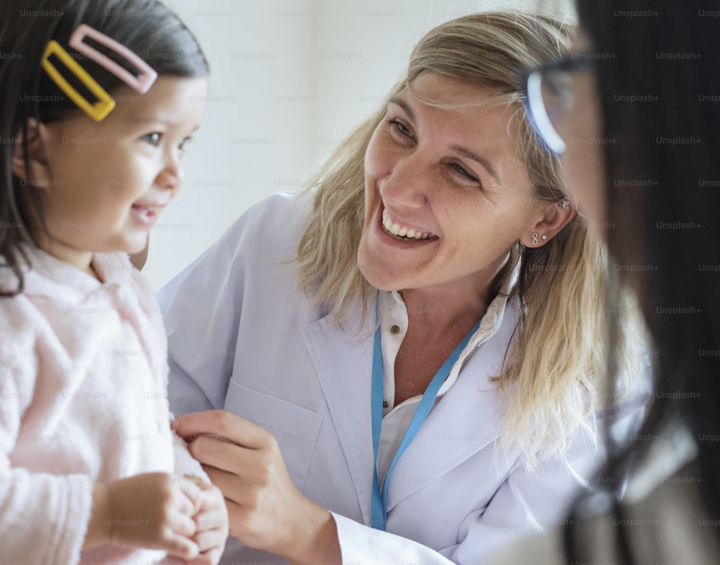 Pediatrician smiling with a young girl during a clinic visit