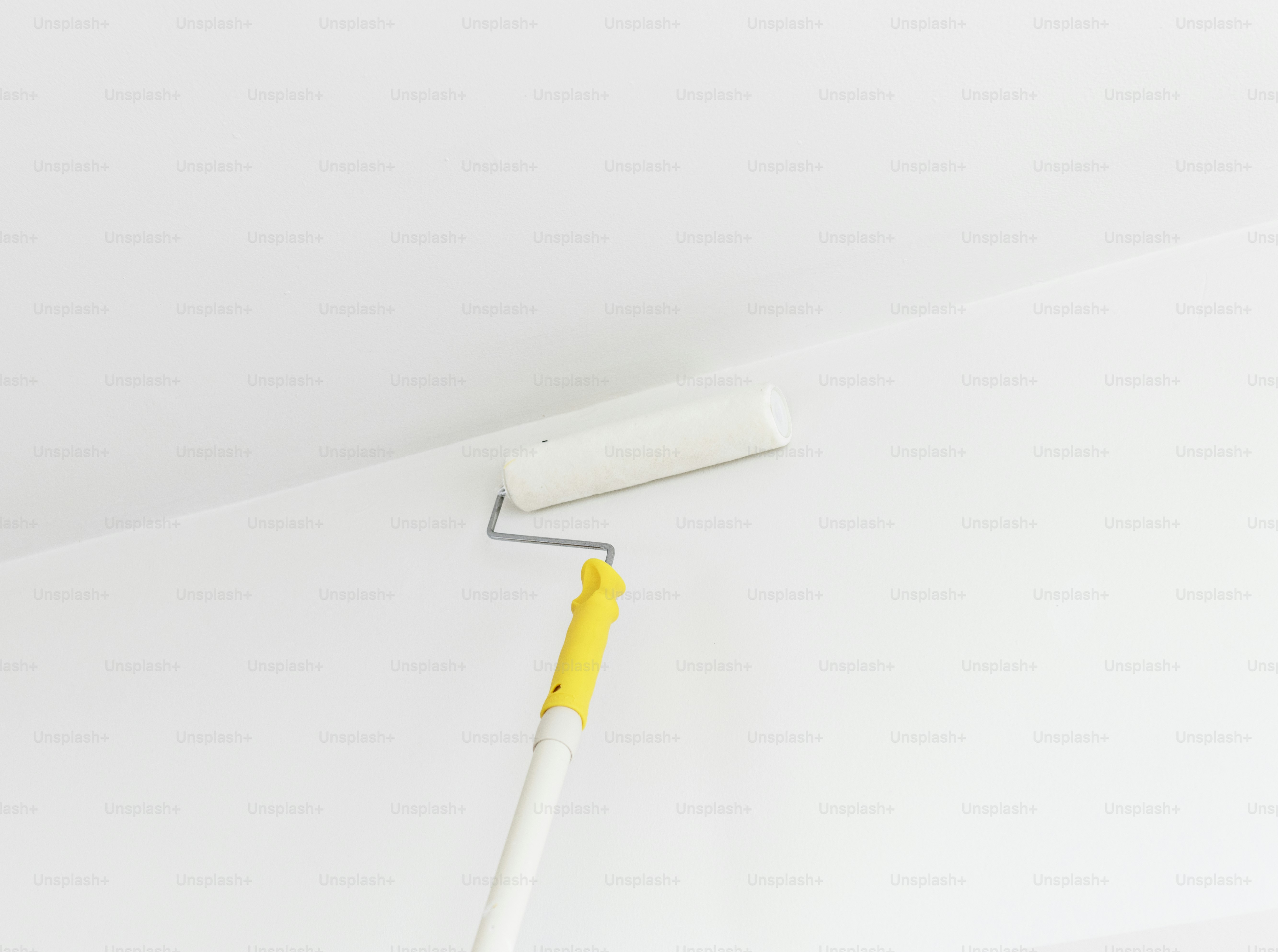 People renovating the house by using paint roller