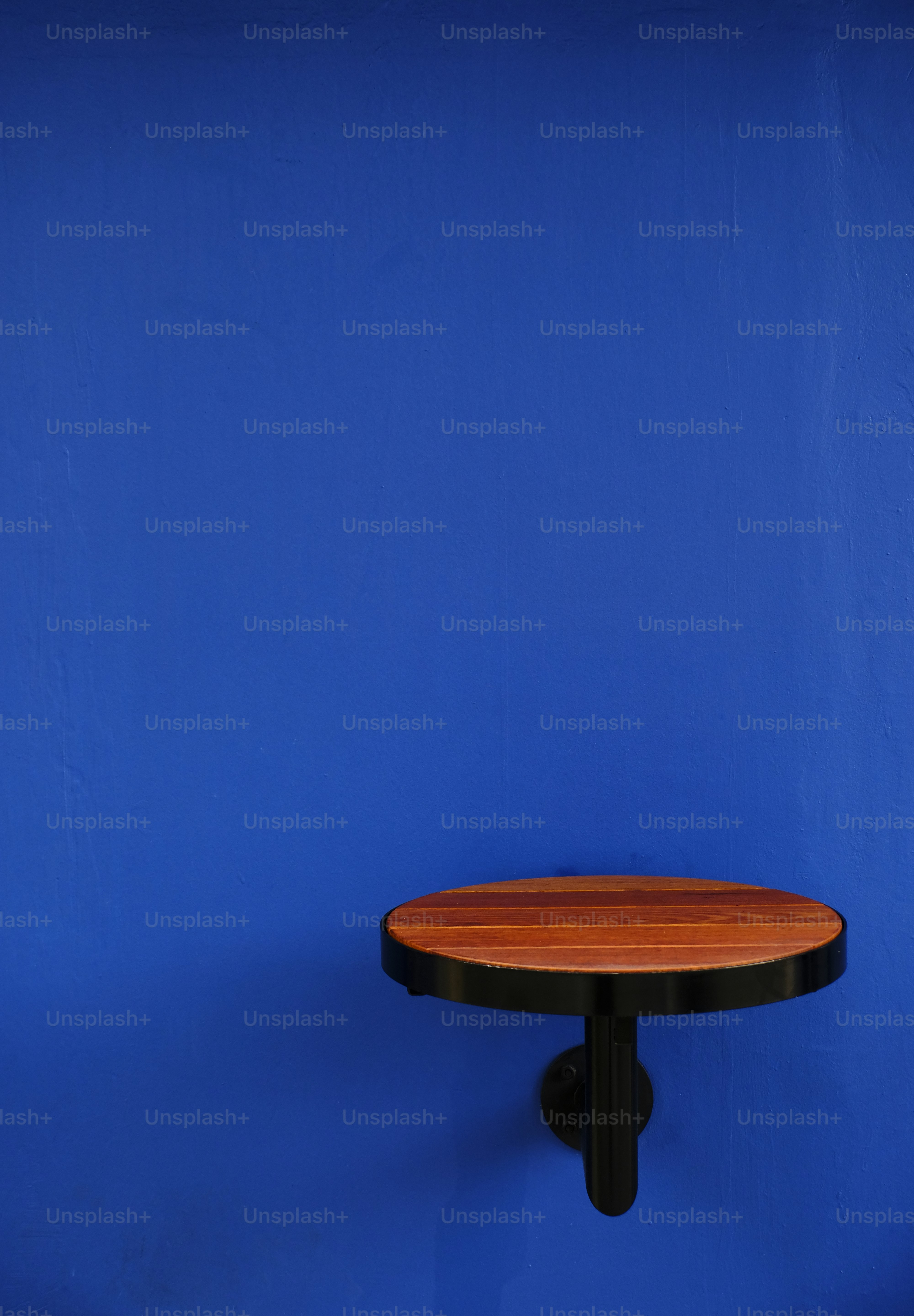 Round wooden table attached to a wall