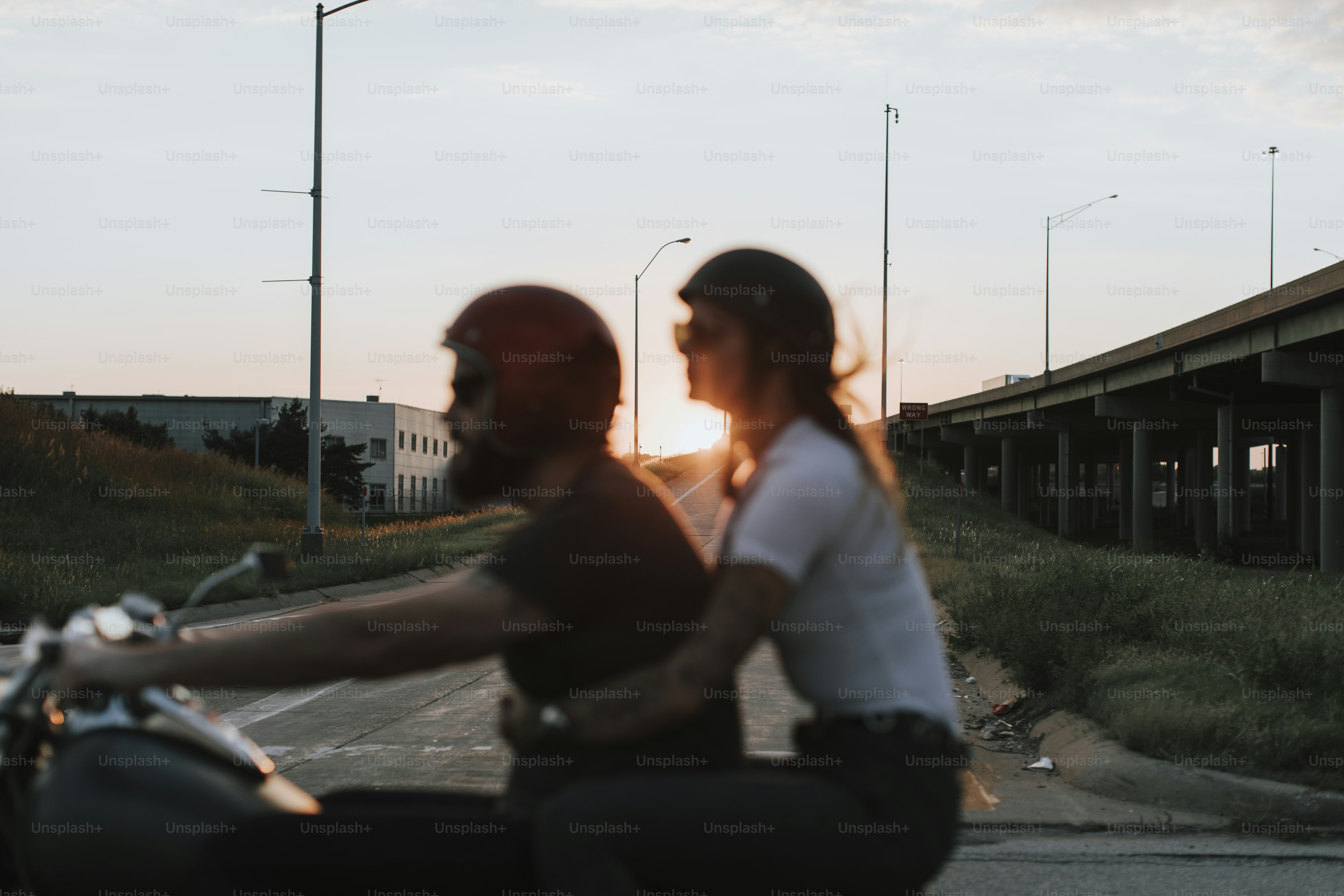 Biker couple riding down the road in the sunset