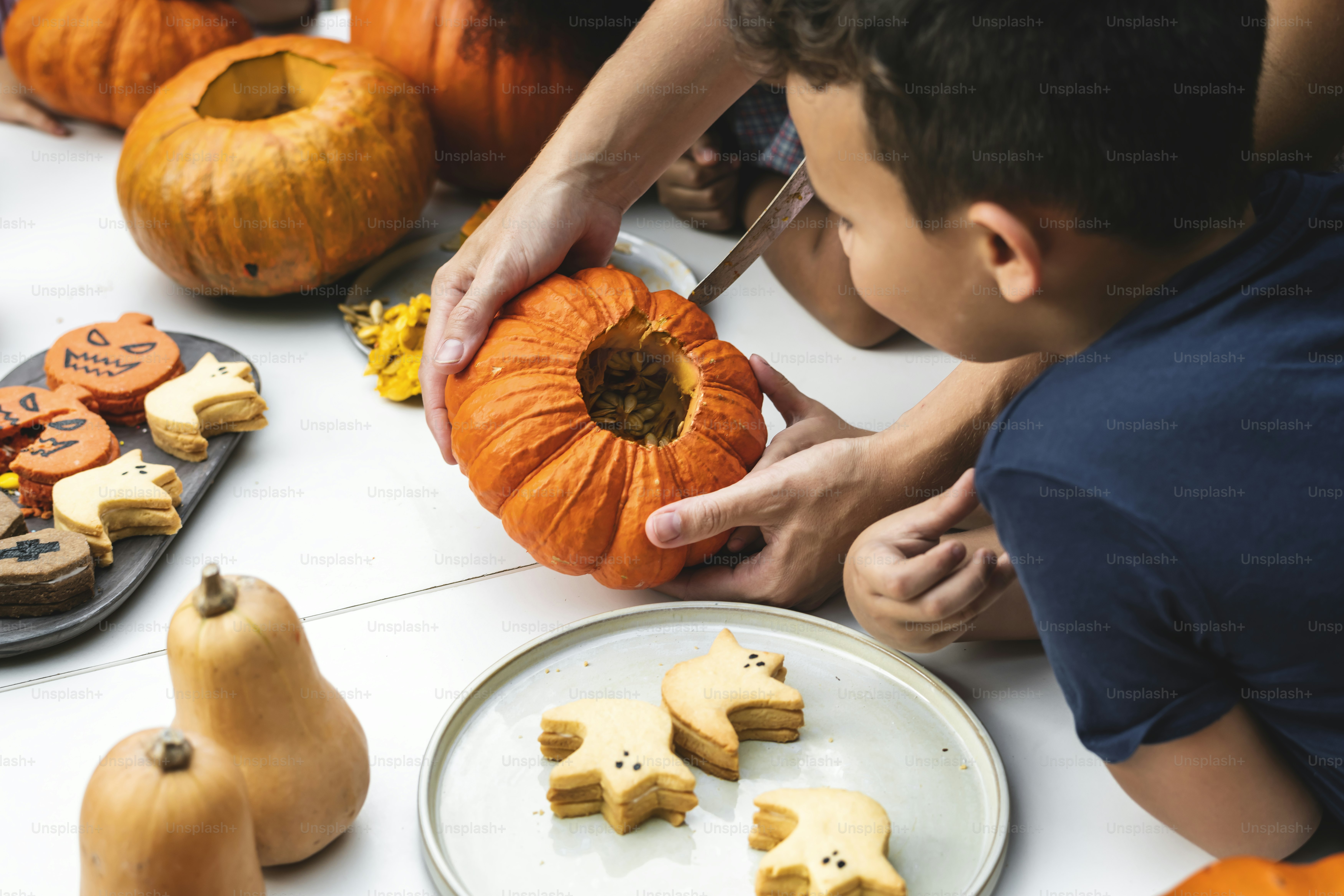De jeunes enfants sculptent des lanternes jack-o' d’Halloween