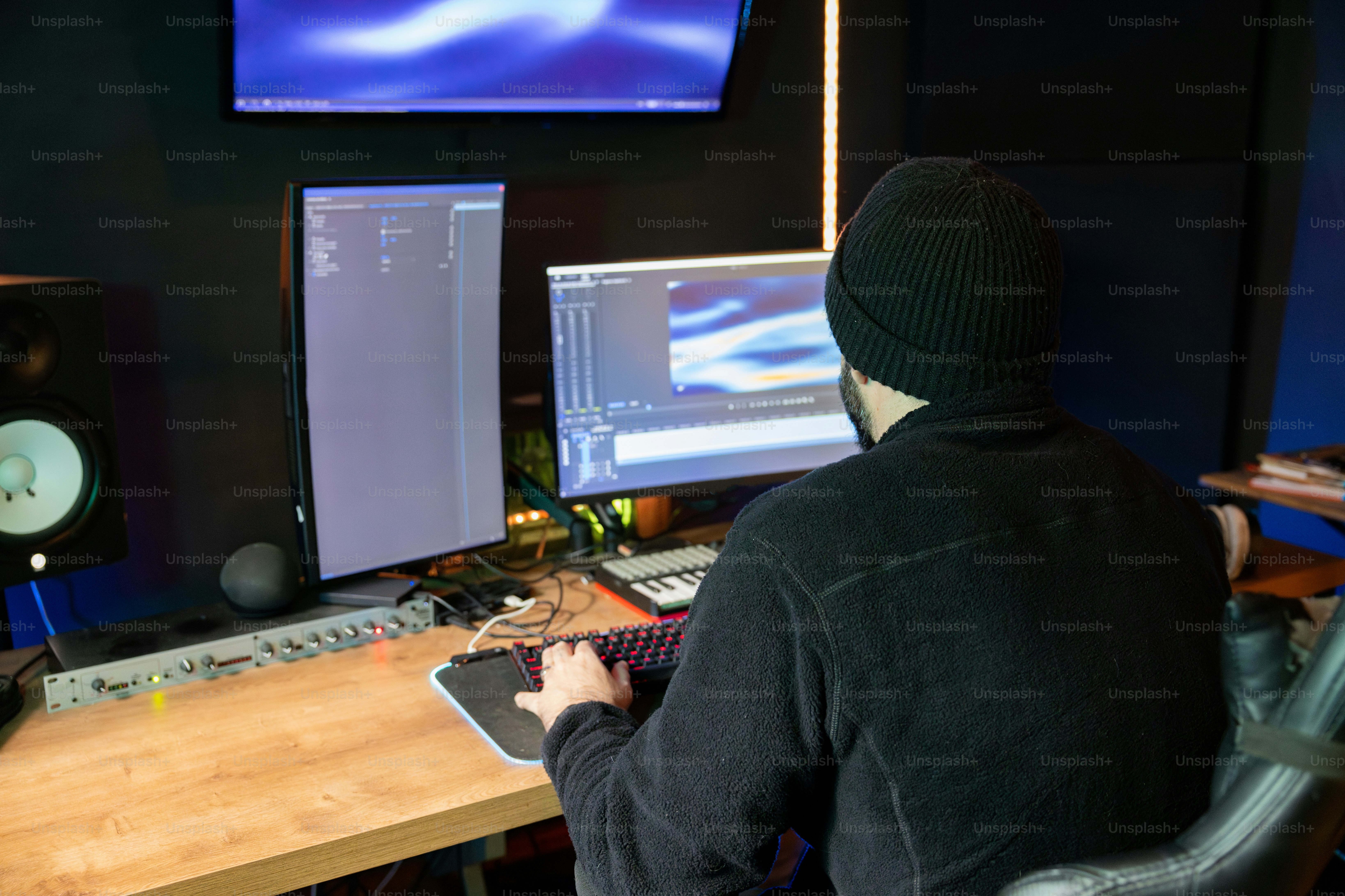 A man sitting in front of a computer desk photo – Video editor Image on ...