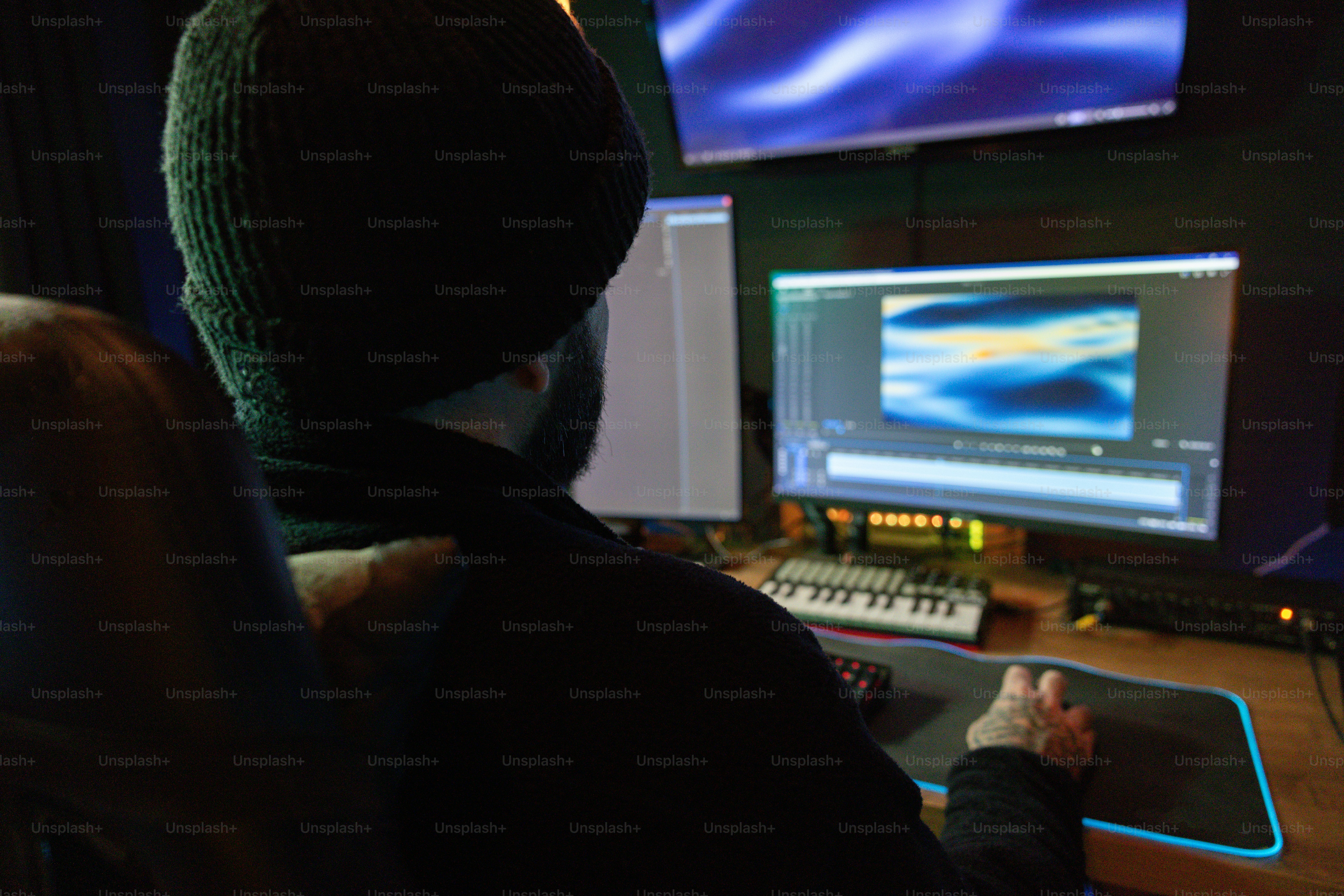 A person sitting in front of a computer monitor photo – Video editing ...