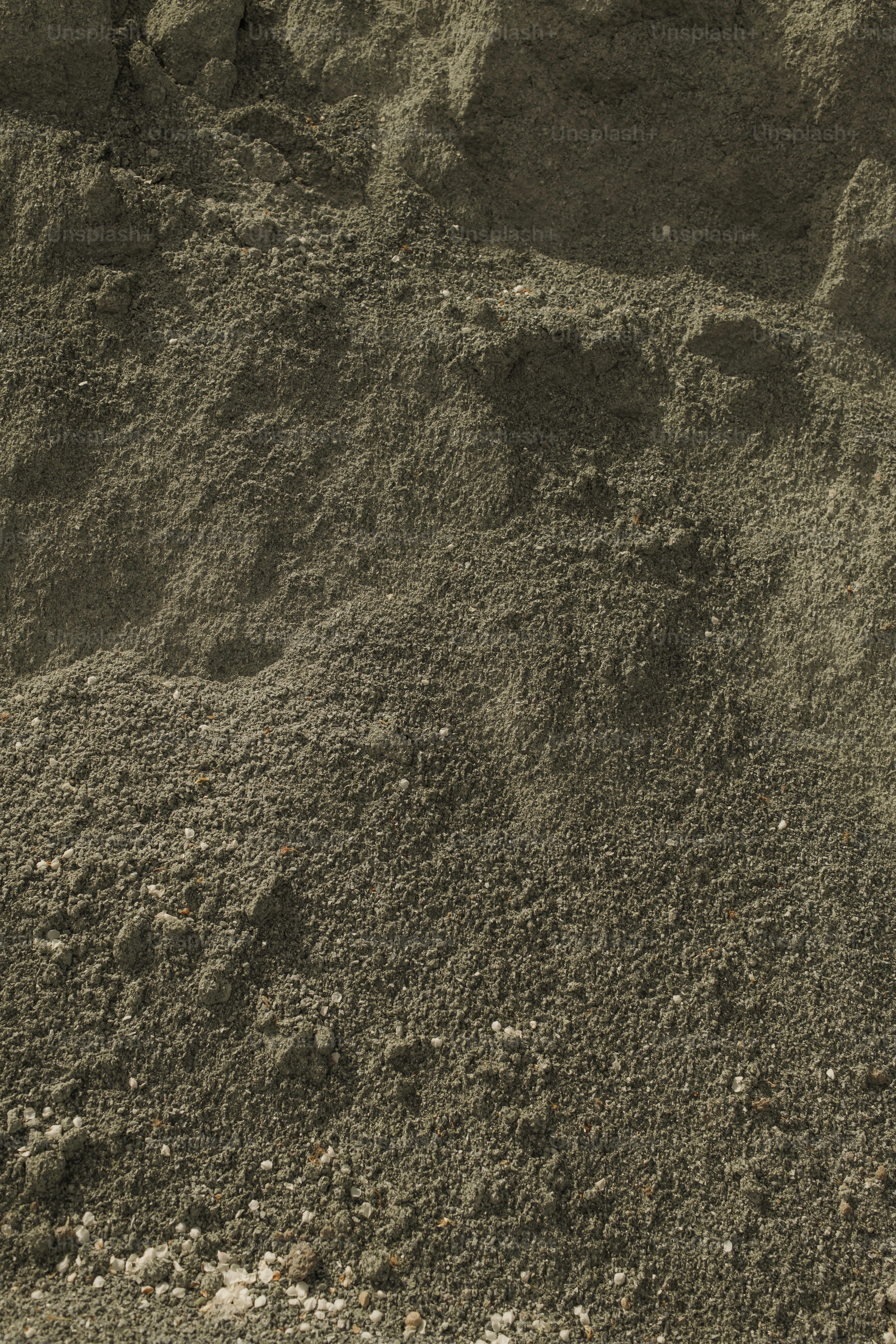 Uma pilha de sujeira sentada no topo de uma praia arenosa