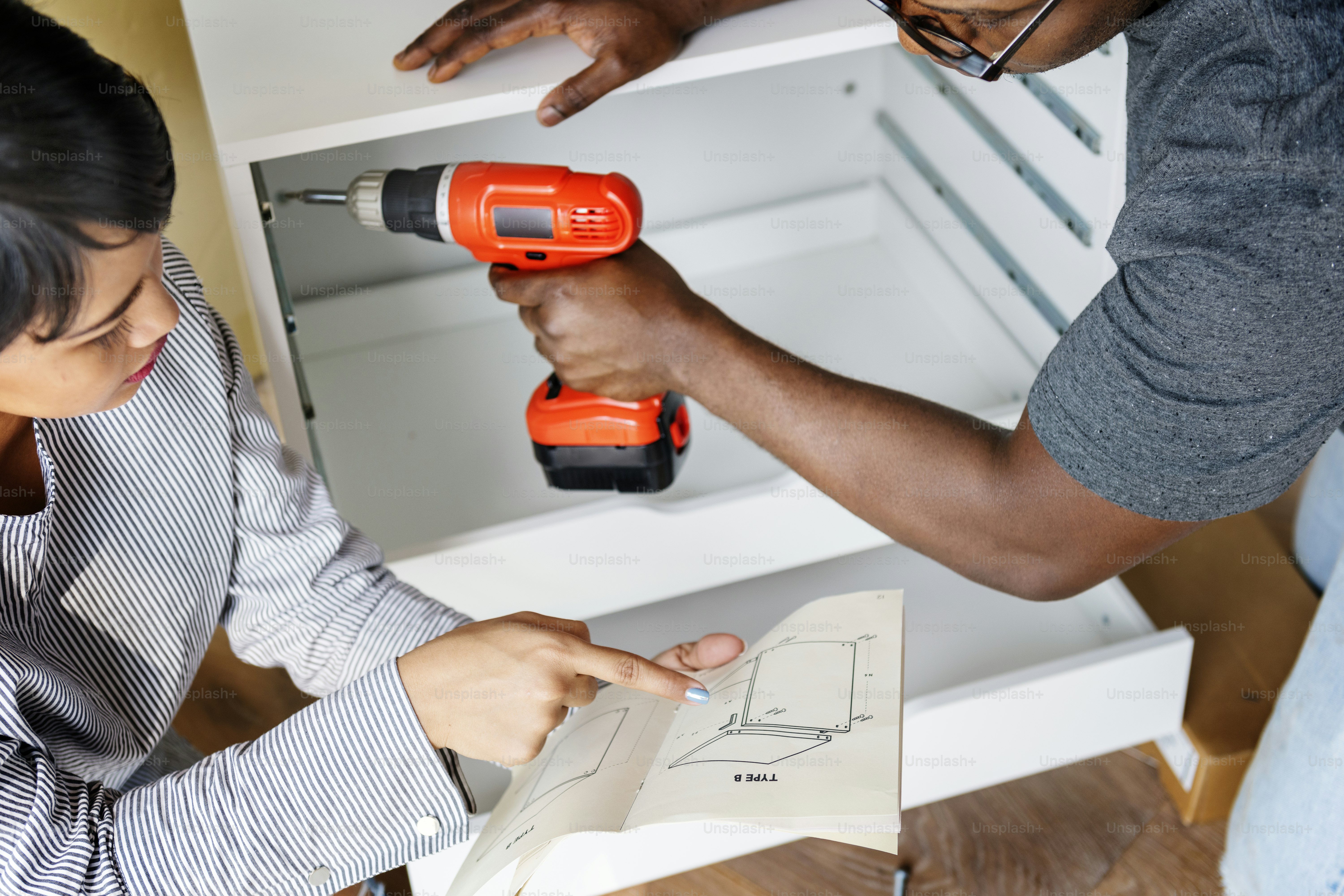 Mann mit elektronischer Bohrmaschine Installationsschrank