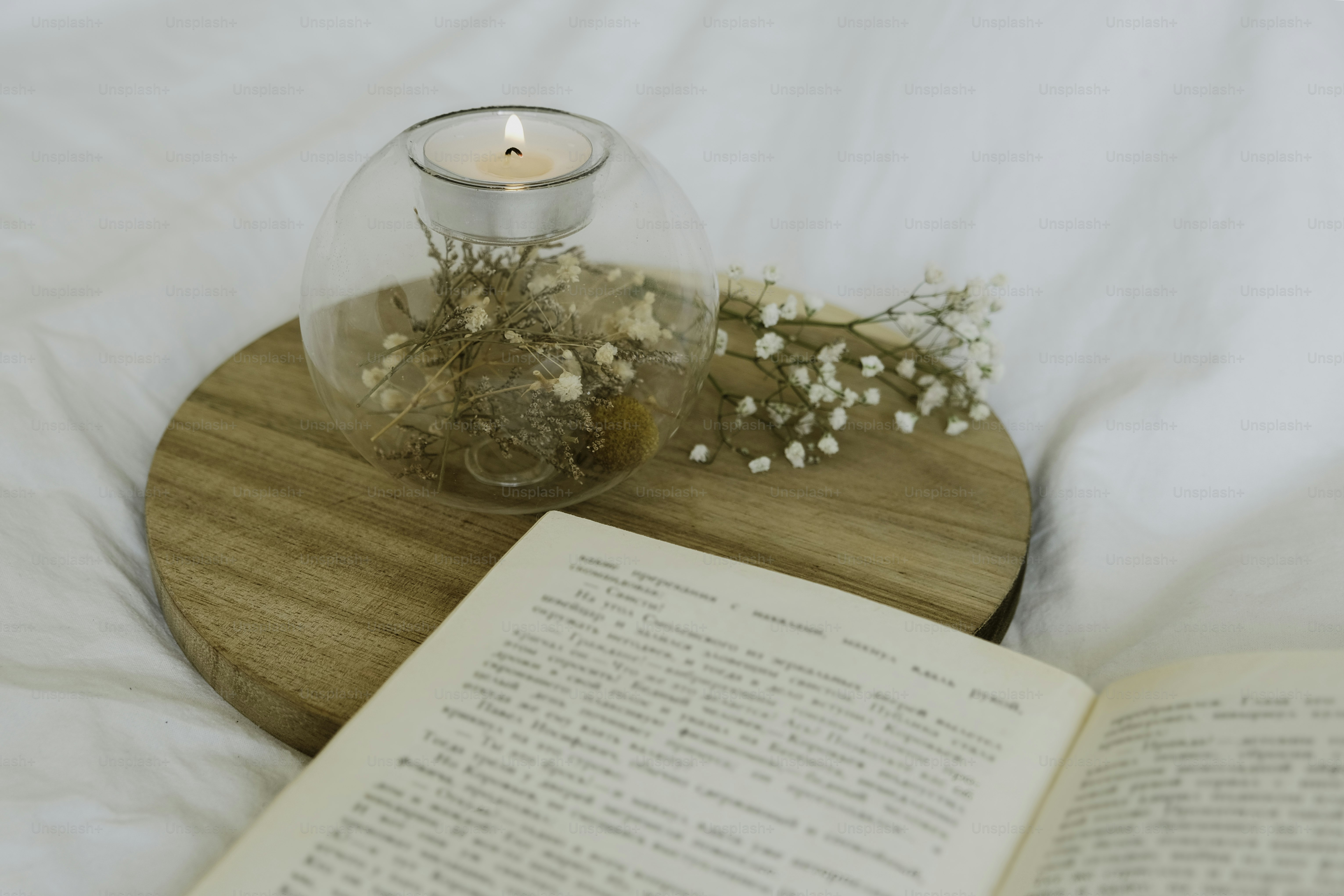 A book and a candle on a bed