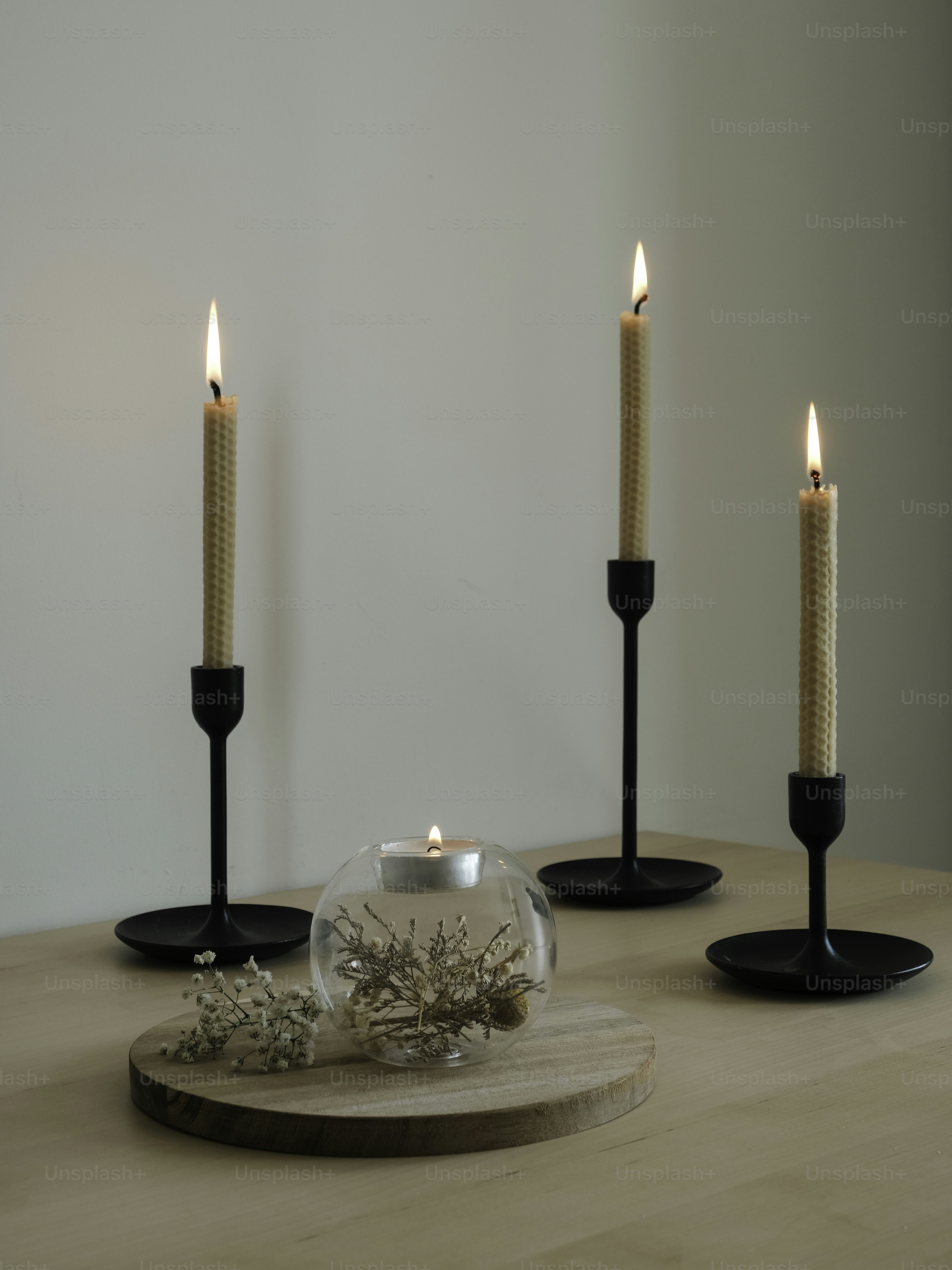 Meja kayu di atasnya dengan tiga lilin hitam